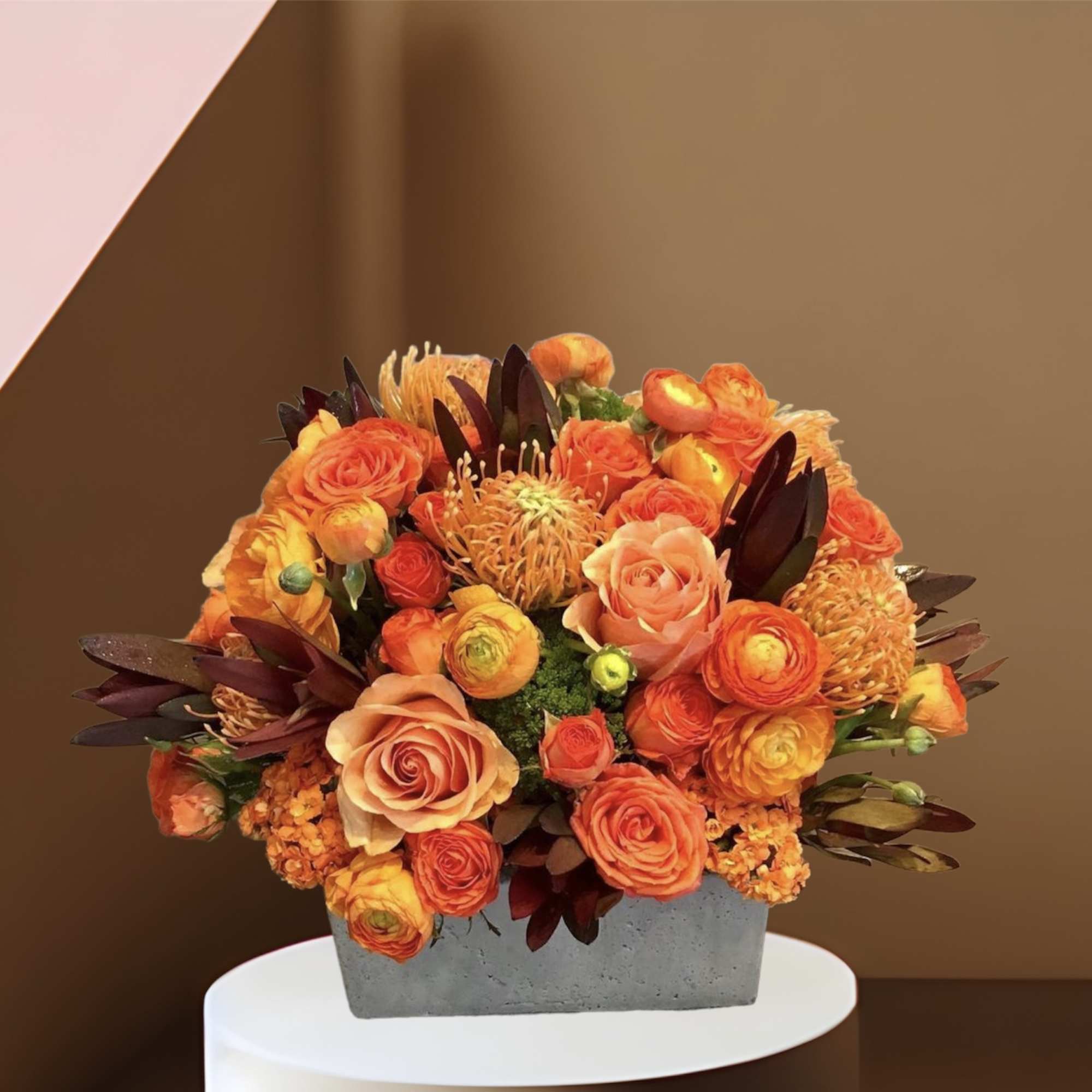 A large arrangement of fall colored roses, ranunculus, protea and other seasonal