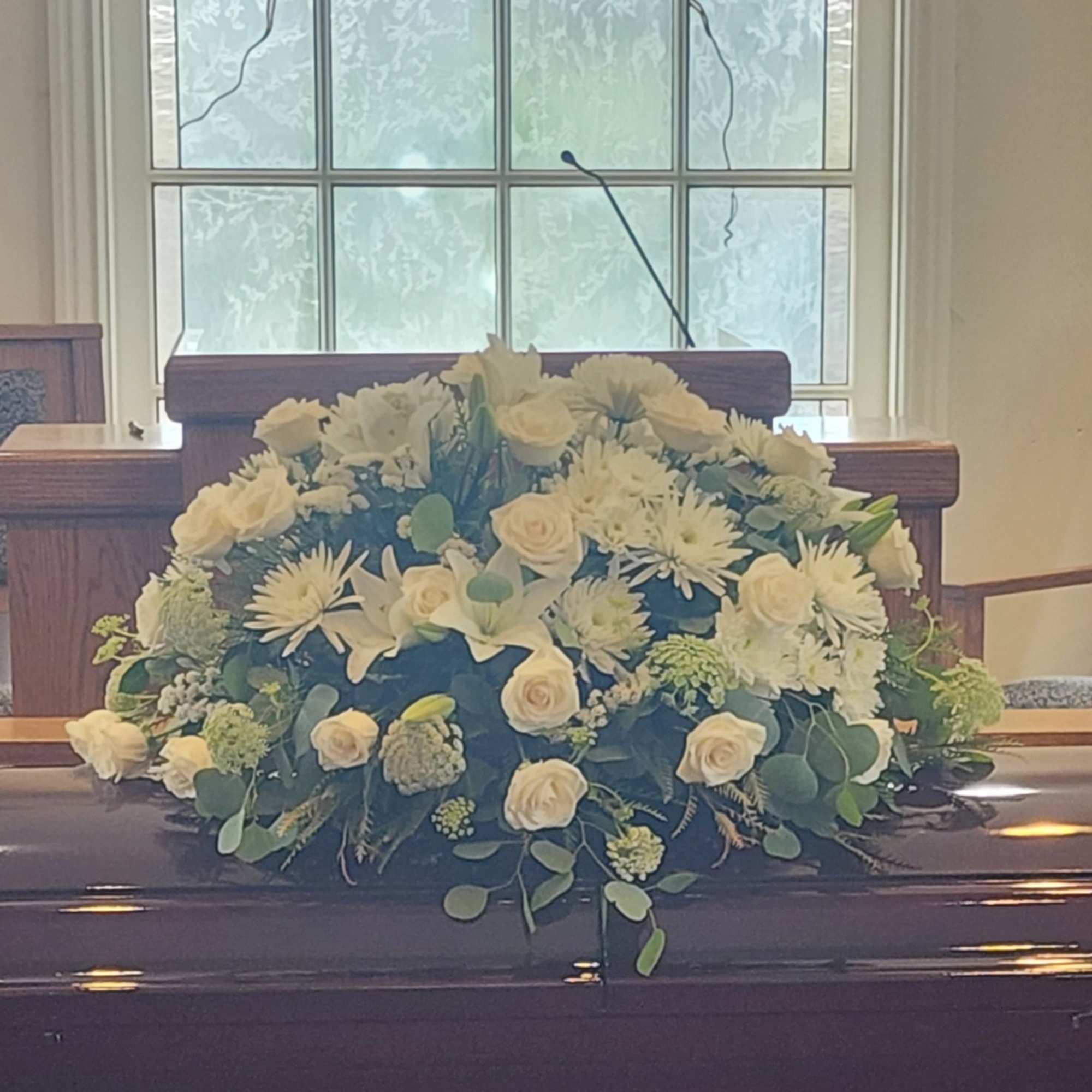 An all white tribute, this full casket spray is pure and tranquil.