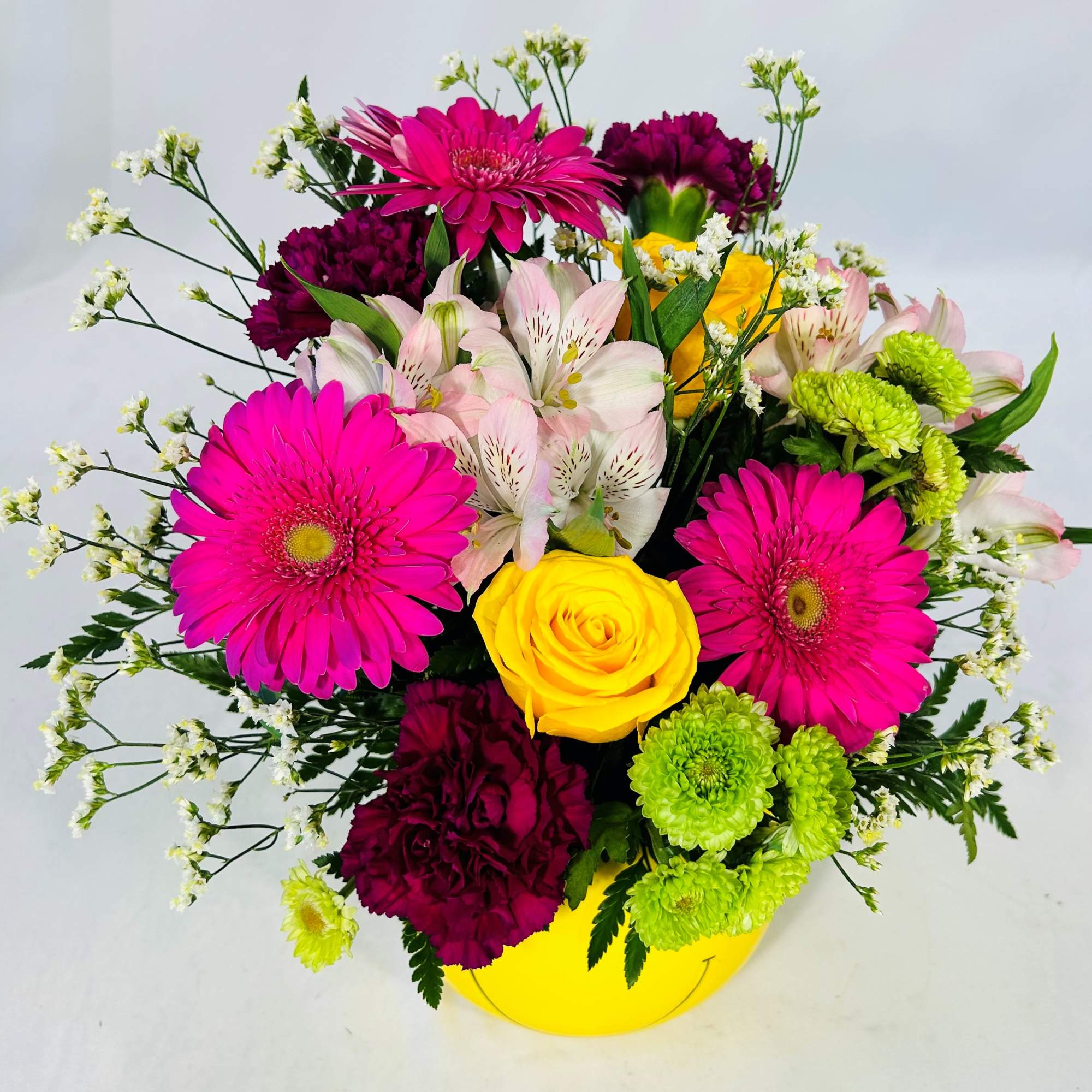 Send a smiley face arrangement to bright up someone's day. This smiley Send a smiley face arrangement to bright up someone's day. This smiley