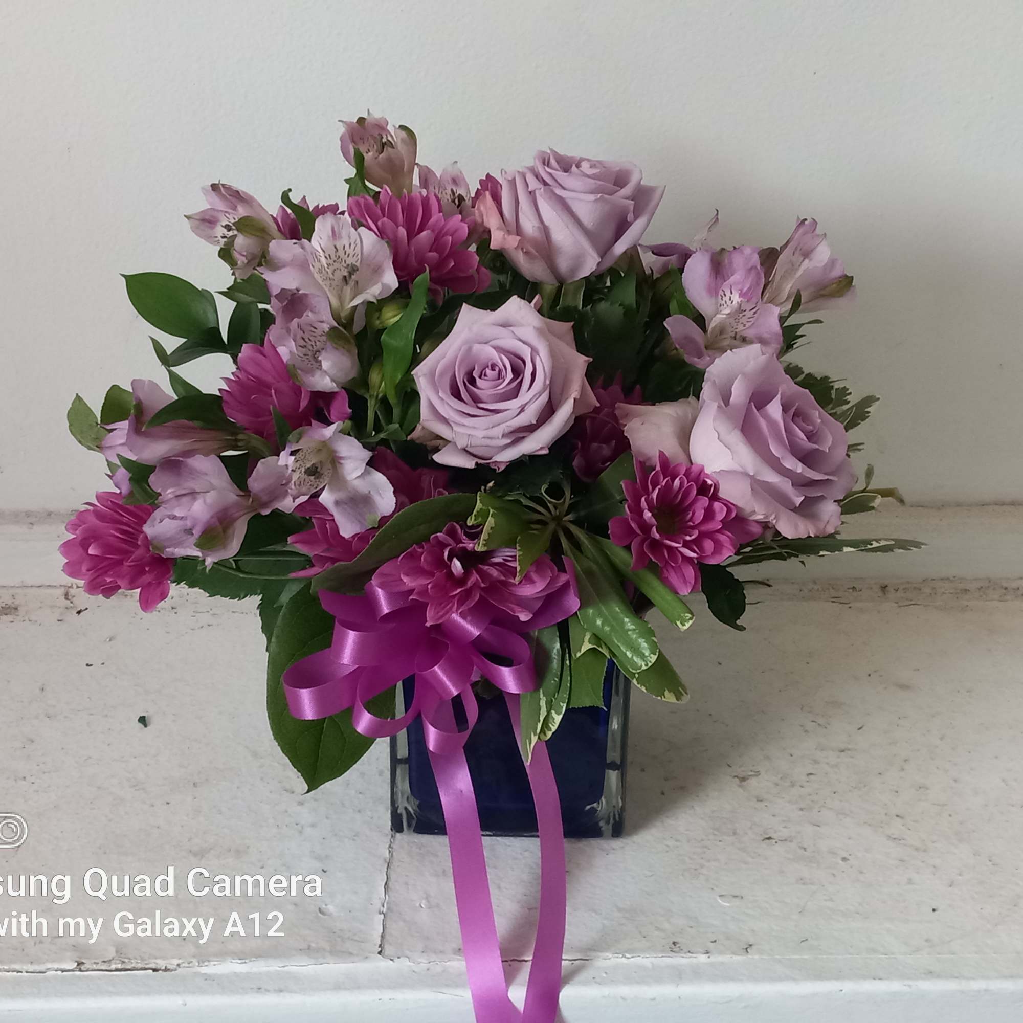 All purple roses, alstroemeria and deaiies in a vase