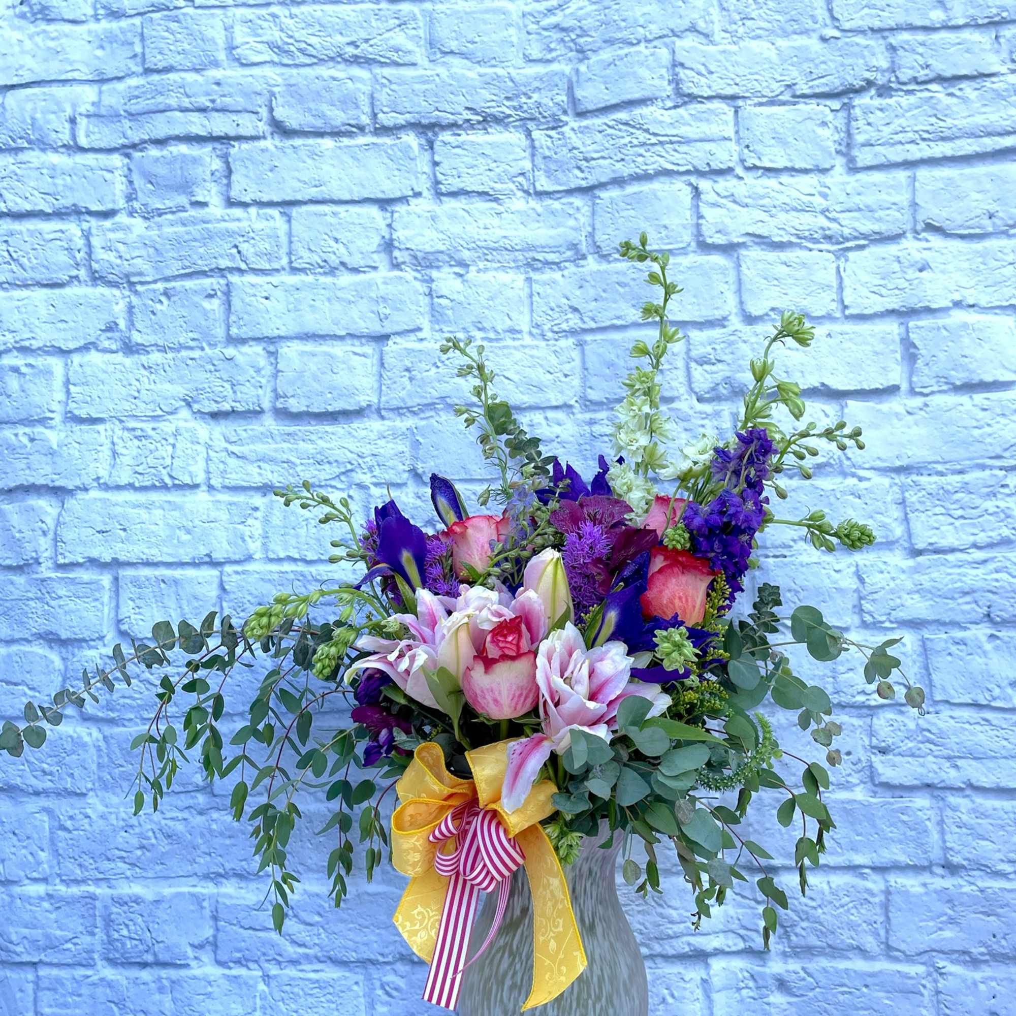 An assortment of fresh flowers in a large vase.