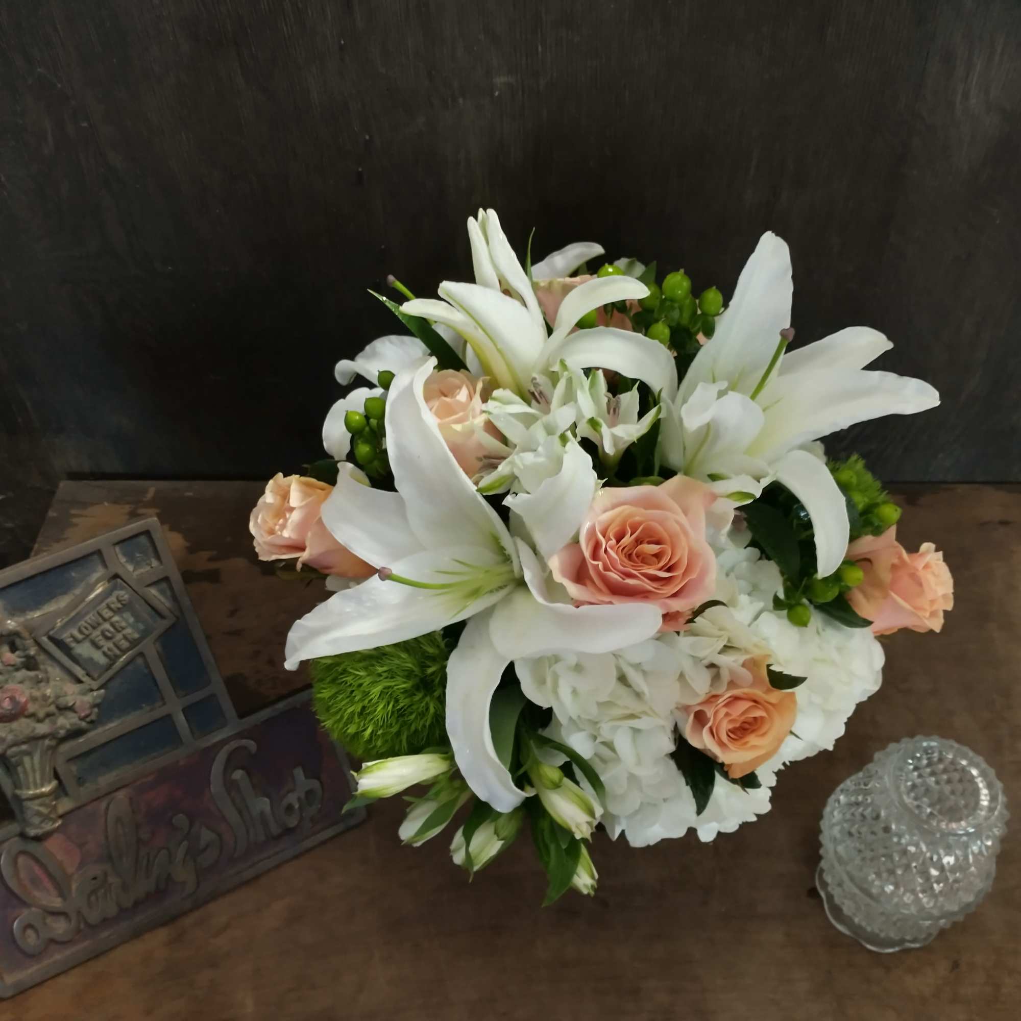 A selection of peach, white and green flowers.  It includes roses