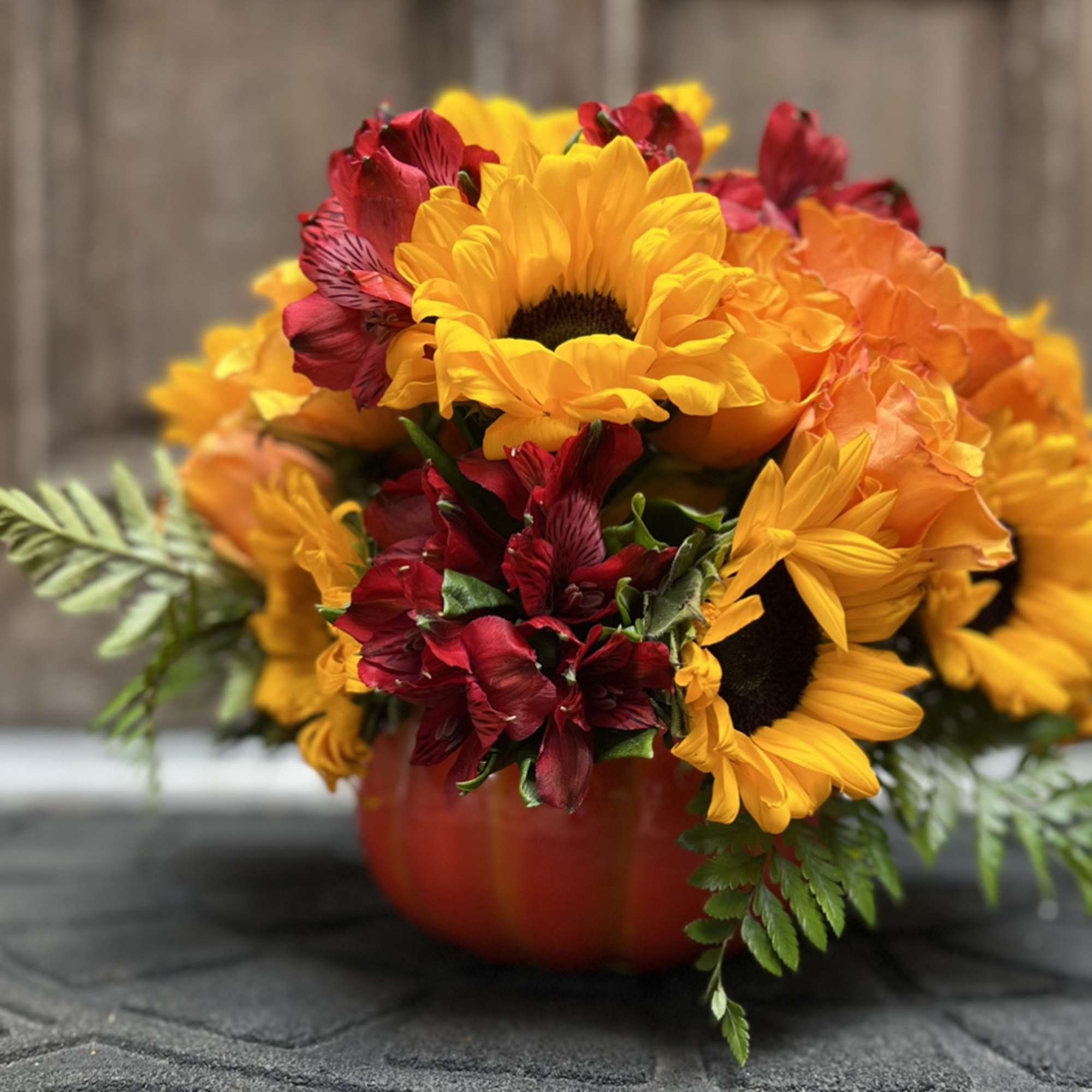Designers Choice of an array of orange roses, bold and bright sunflowers