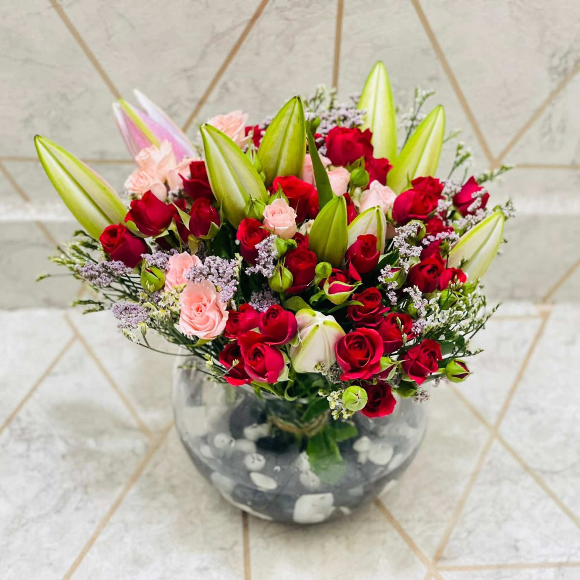 lily and red roses put in a round  base perfect for