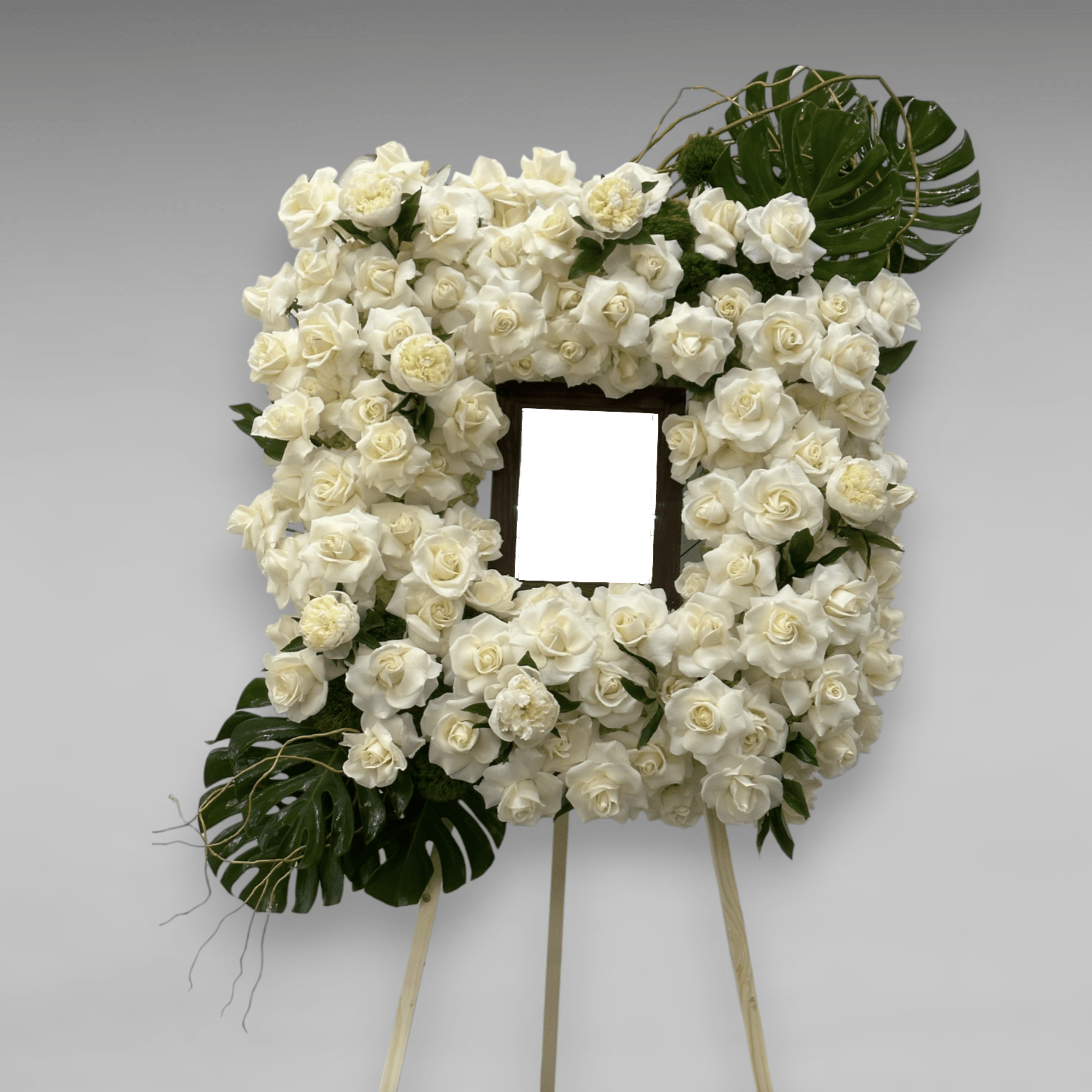 A funeral piece designed as a frame. Filled with fresh florals, roses