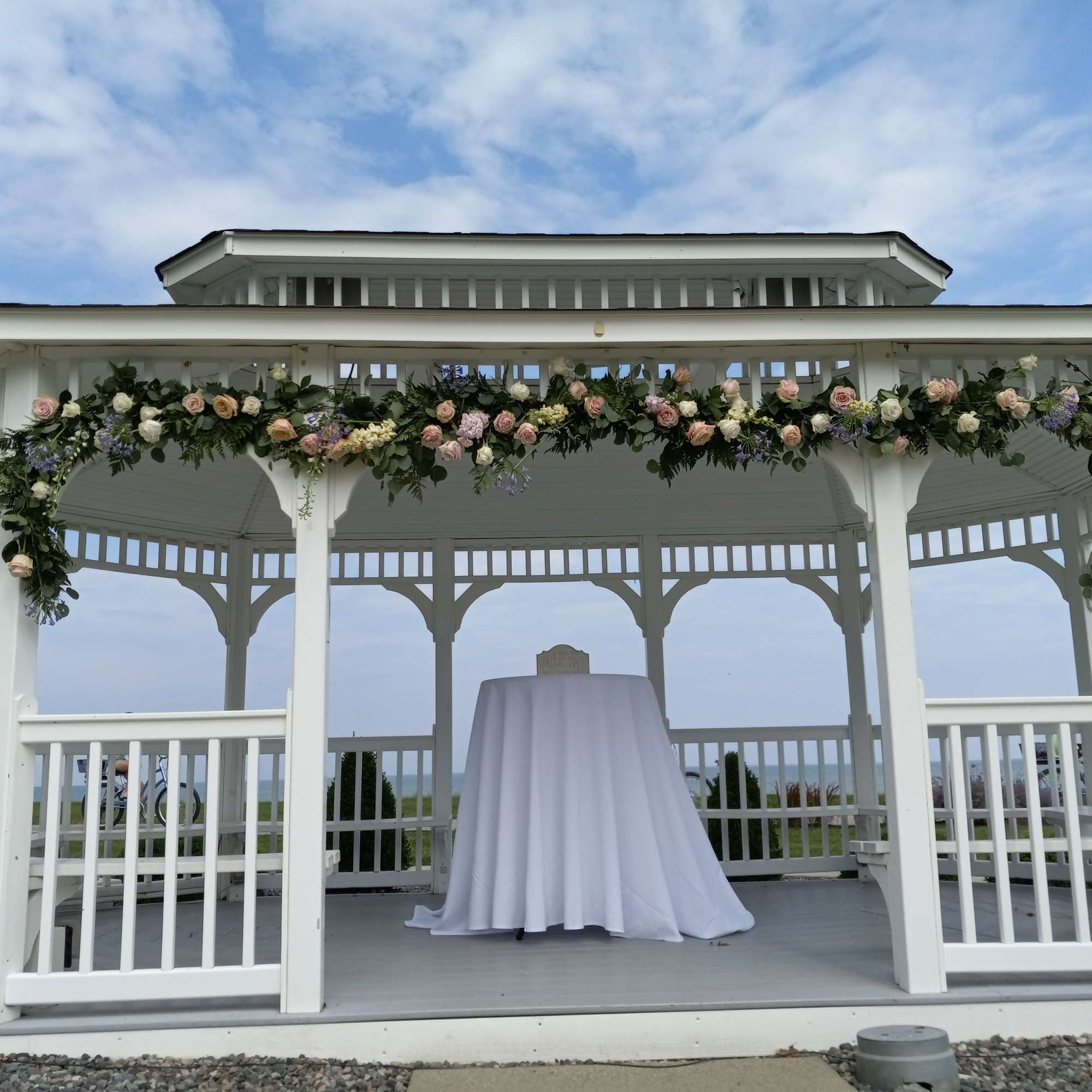 Beautiful Light colors white and pink roses, carnations, daisies and greens gazebo