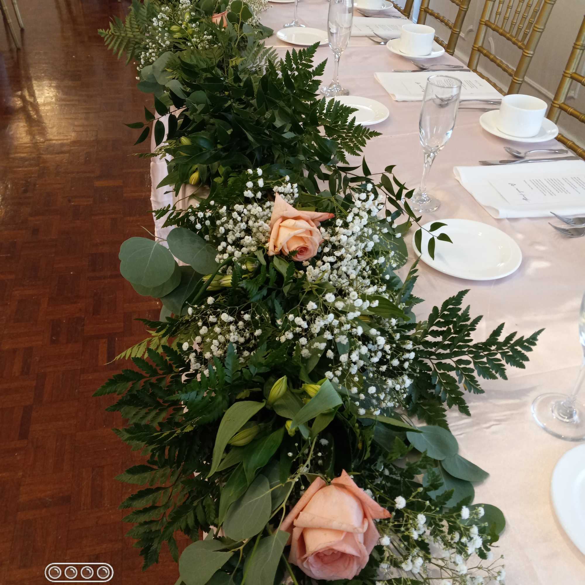 Lush greenery, baby's breath and roses table garland