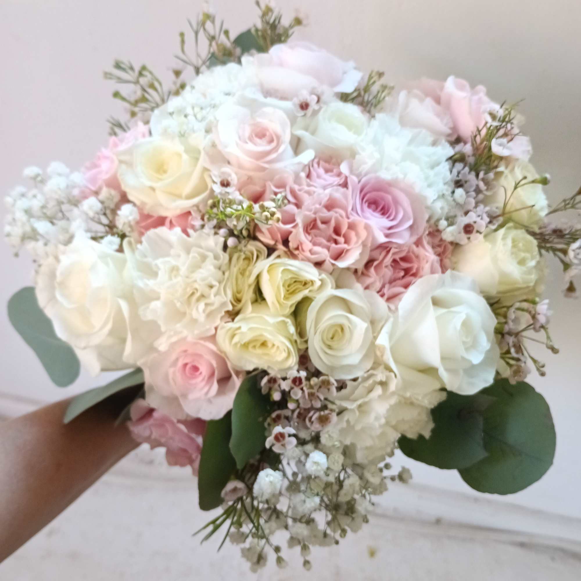 Beautiful and airy white and light pink standard and spray roses, carnations