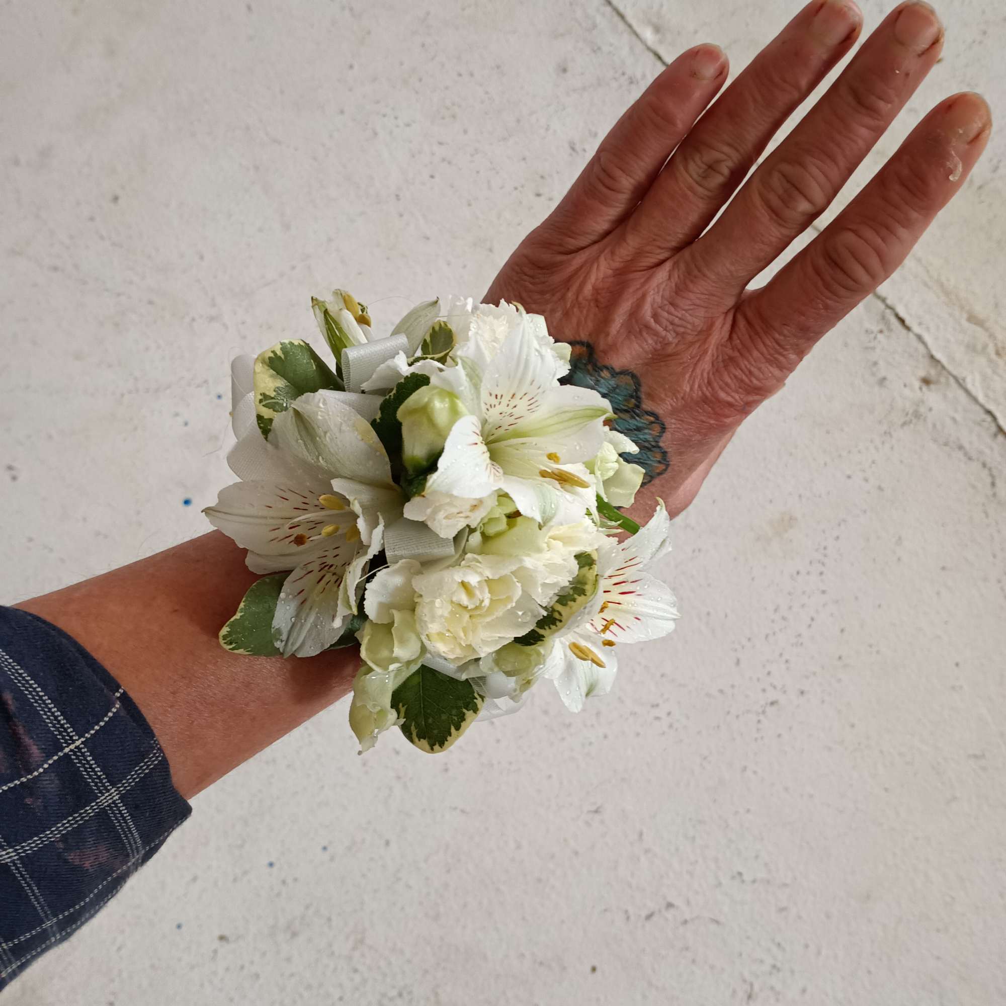 All white alstroemeria, spray carnations and greens corsage