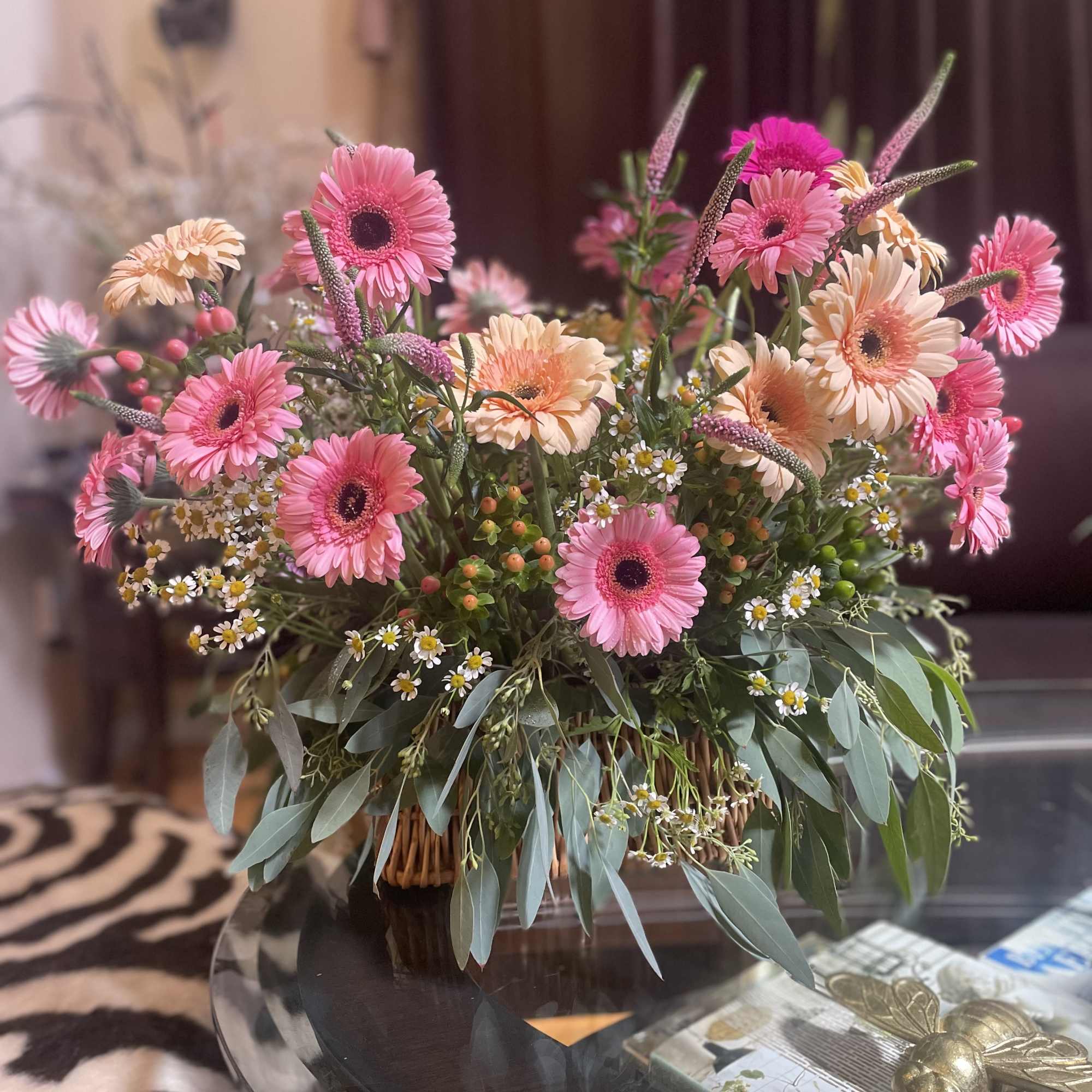 Nestled in a charming picnic basket, a vibrant flower arrangement awaits, adorned