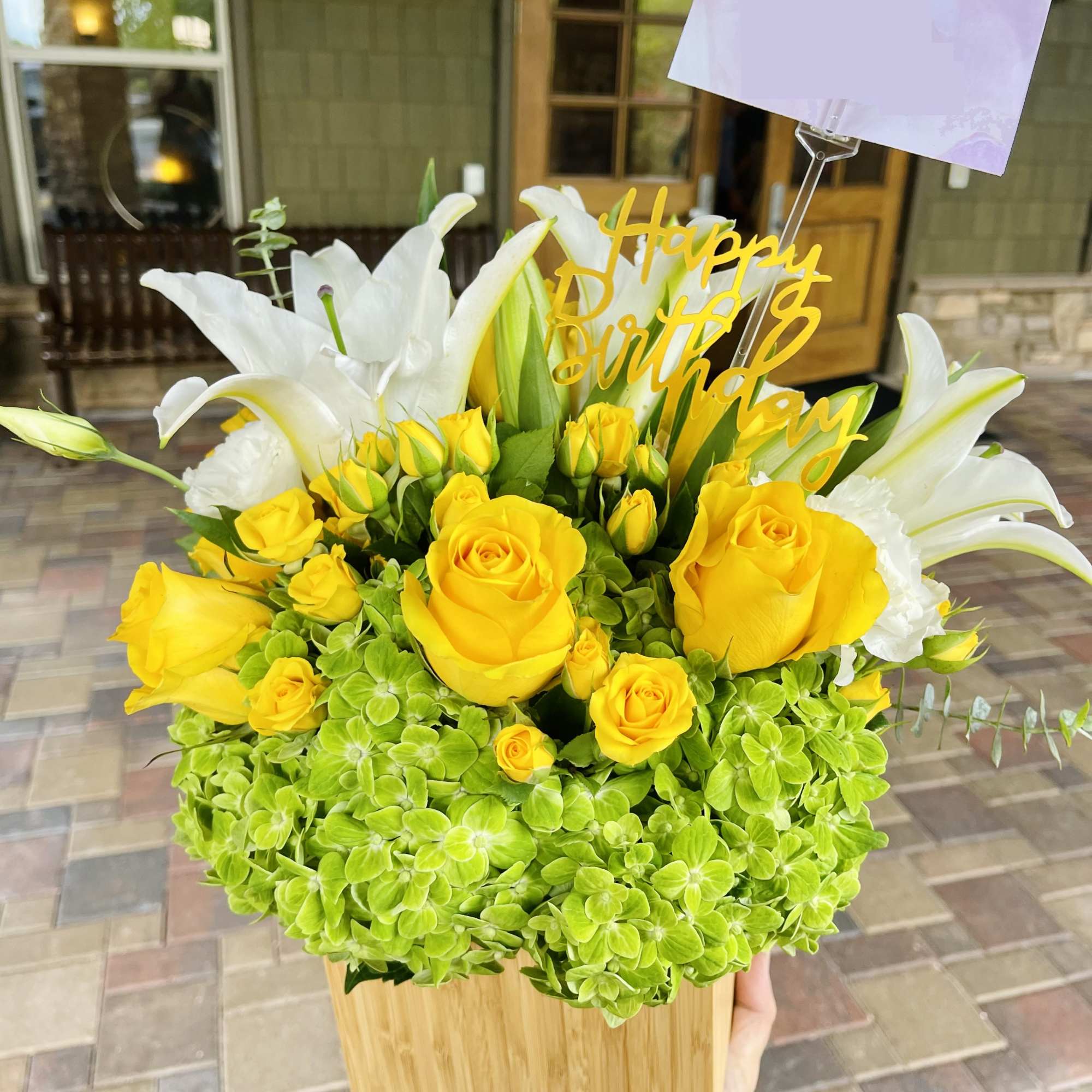 This arrangement features a luxury silver vase filled with white lilies and This arrangement features a luxury silver vase filled with white lilies and