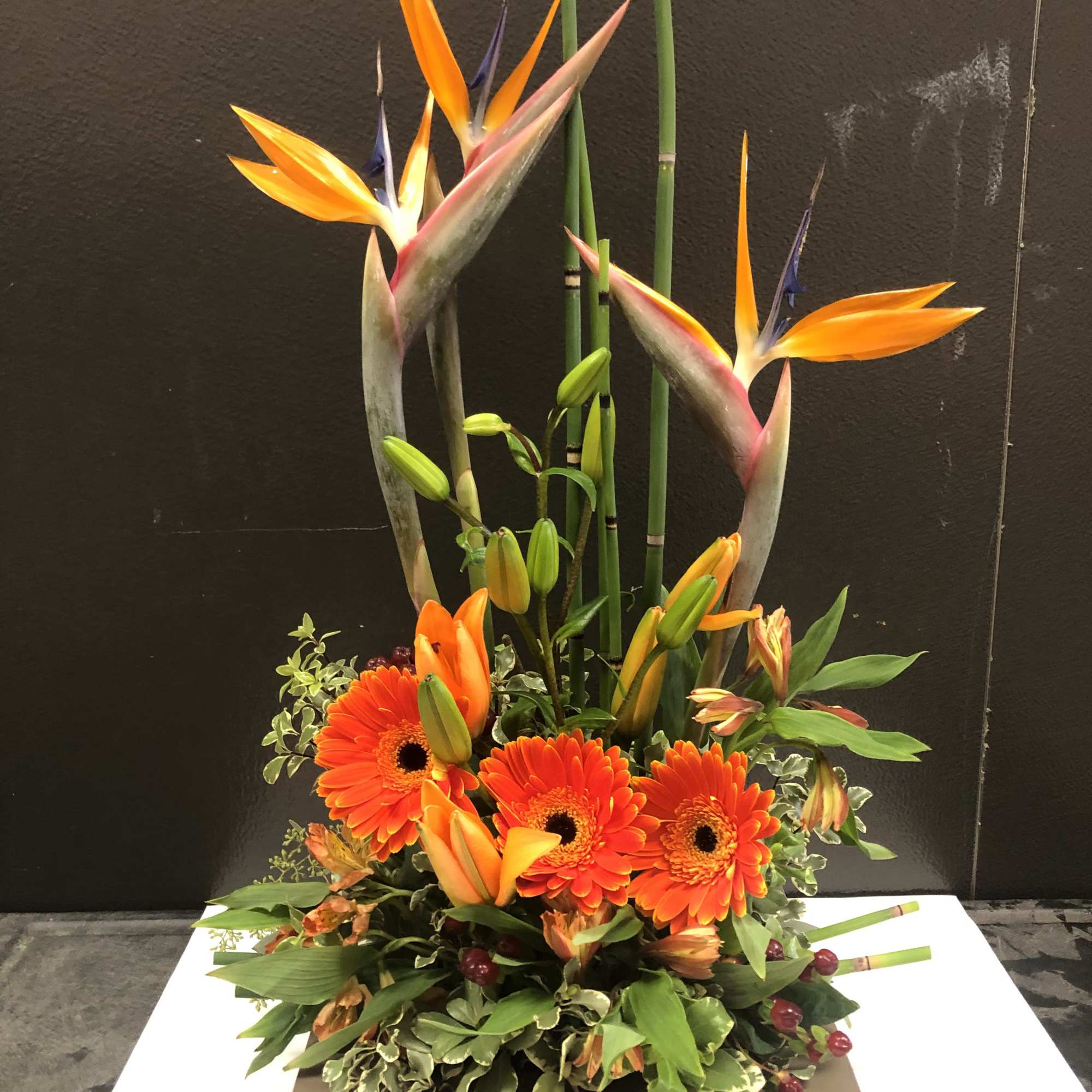 This arrangement is set elegantly with birds of paradise and gerbera in