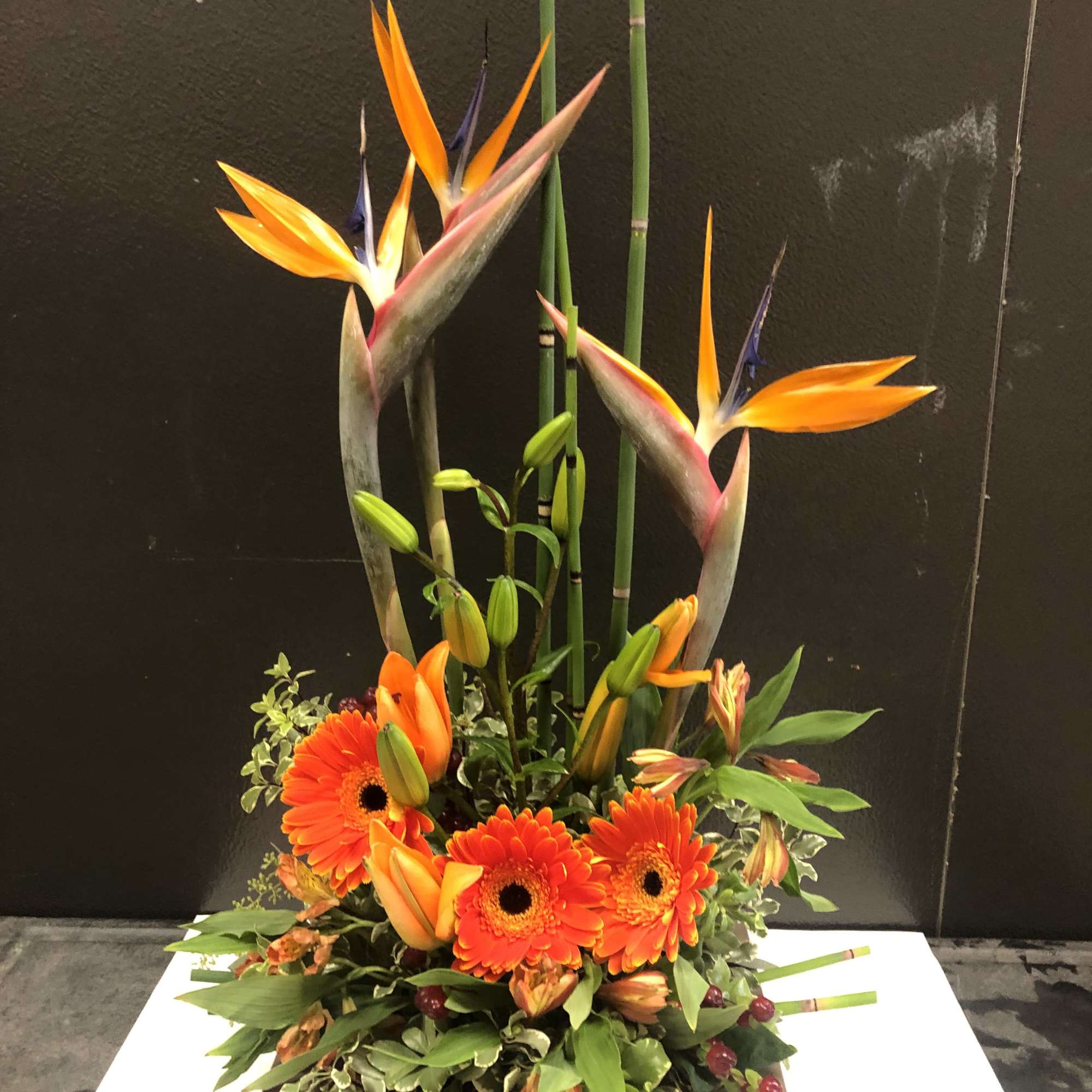 This arrangement is set elegantly with birds of paradise and gerbera in