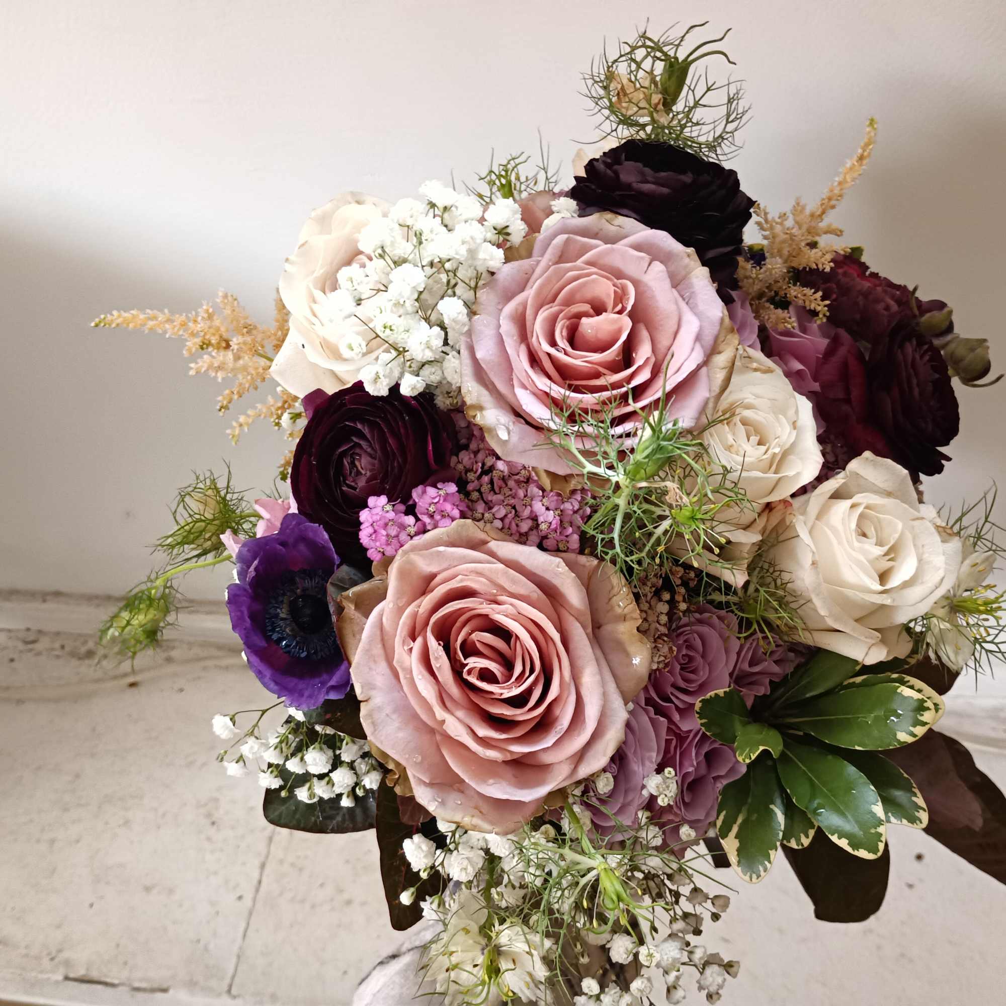Beautiful sophisticated mix of white, purple, burgundy colors with roses, ranunculus, other
