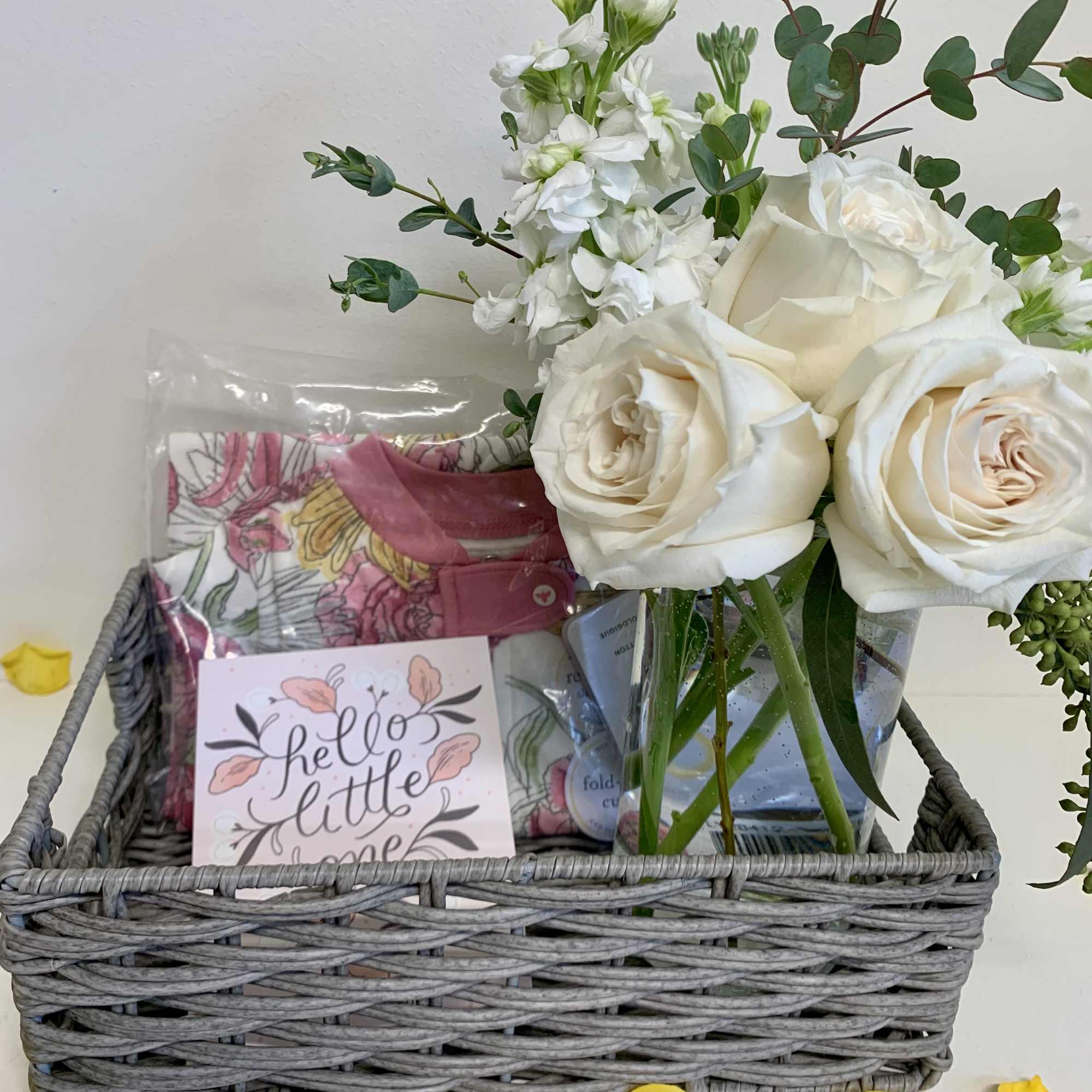 White roses and white stock in a clear glass vase accompanied with
