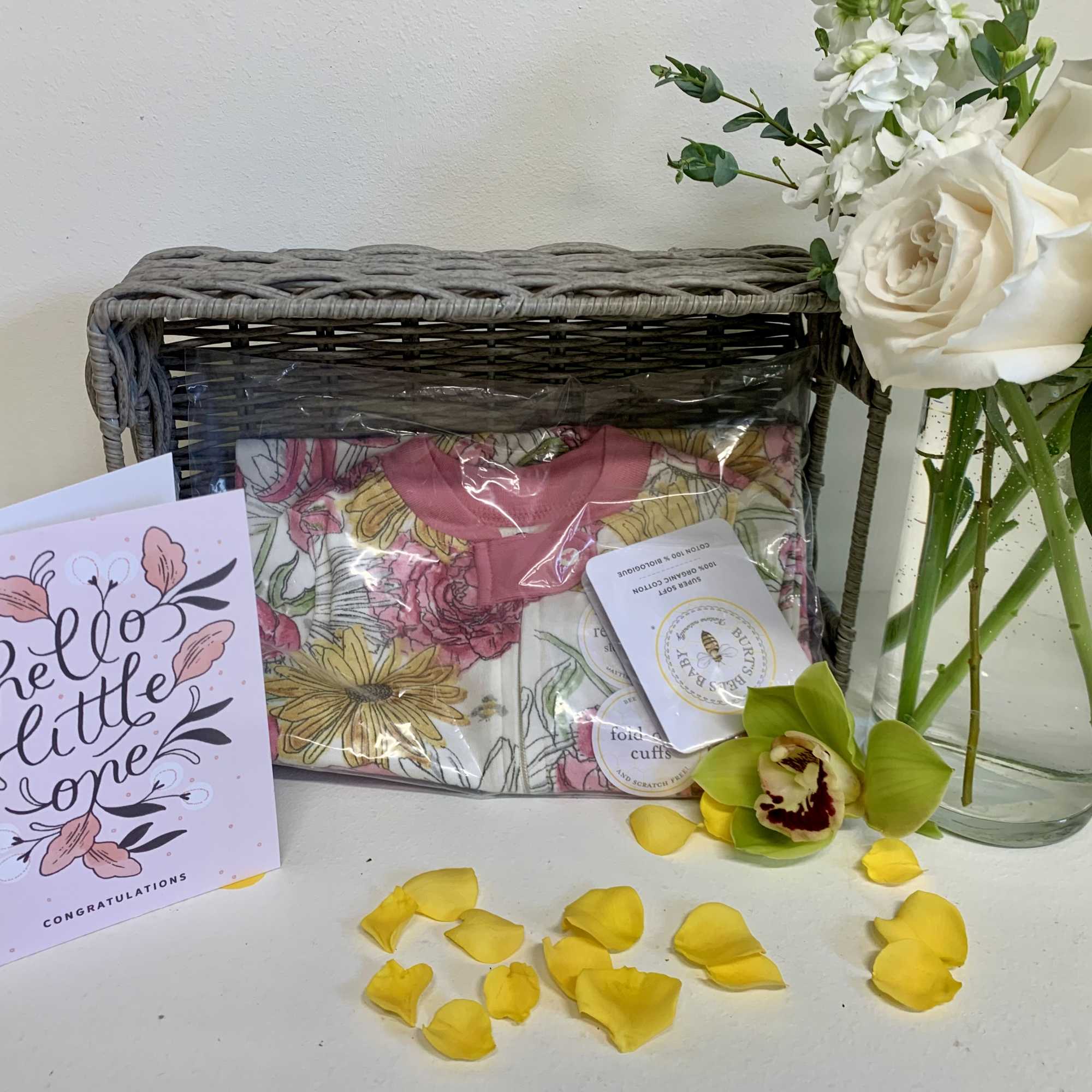 White roses and white stock in a clear glass vase accompanied with