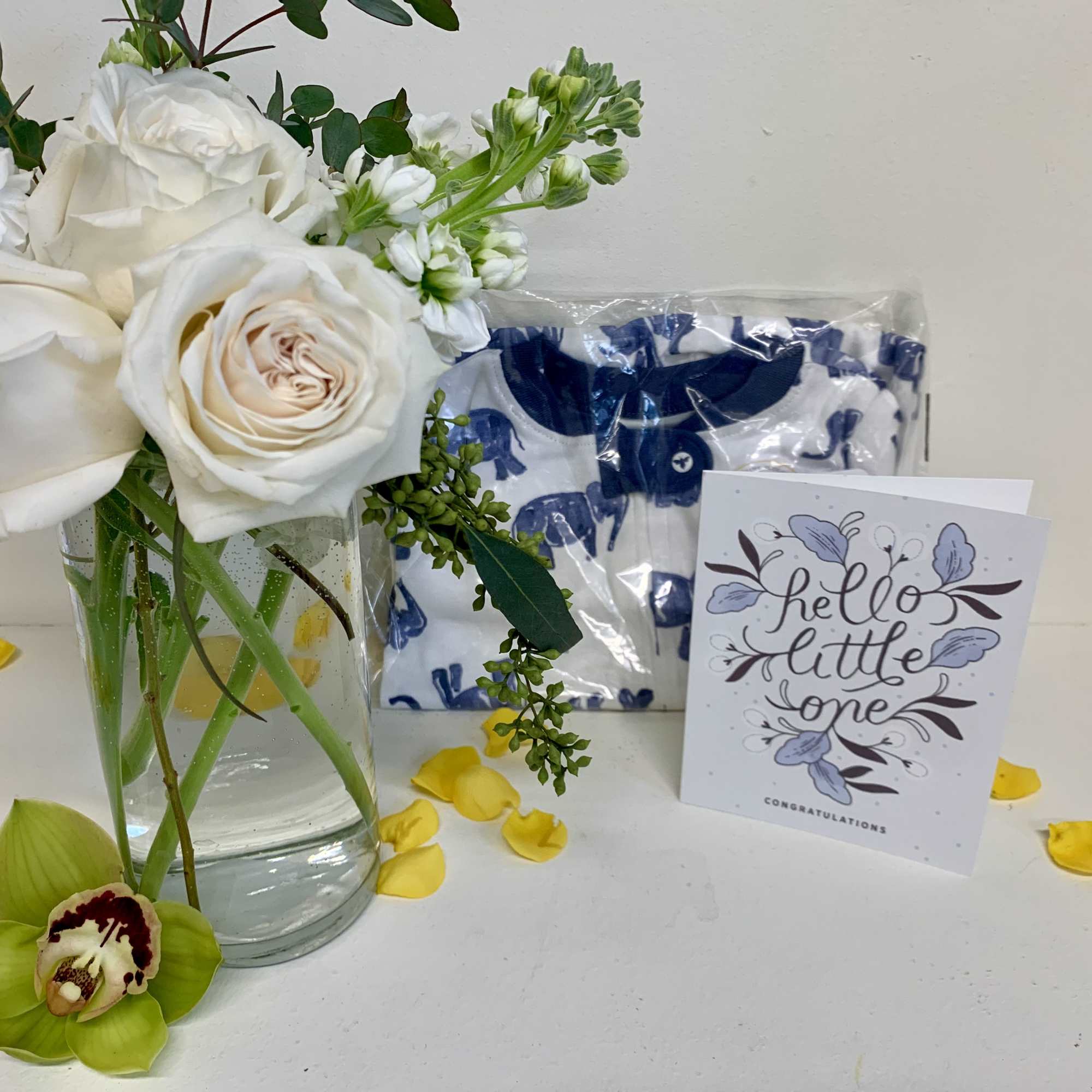 White roses and white stock in a clear glass vase accompanied with