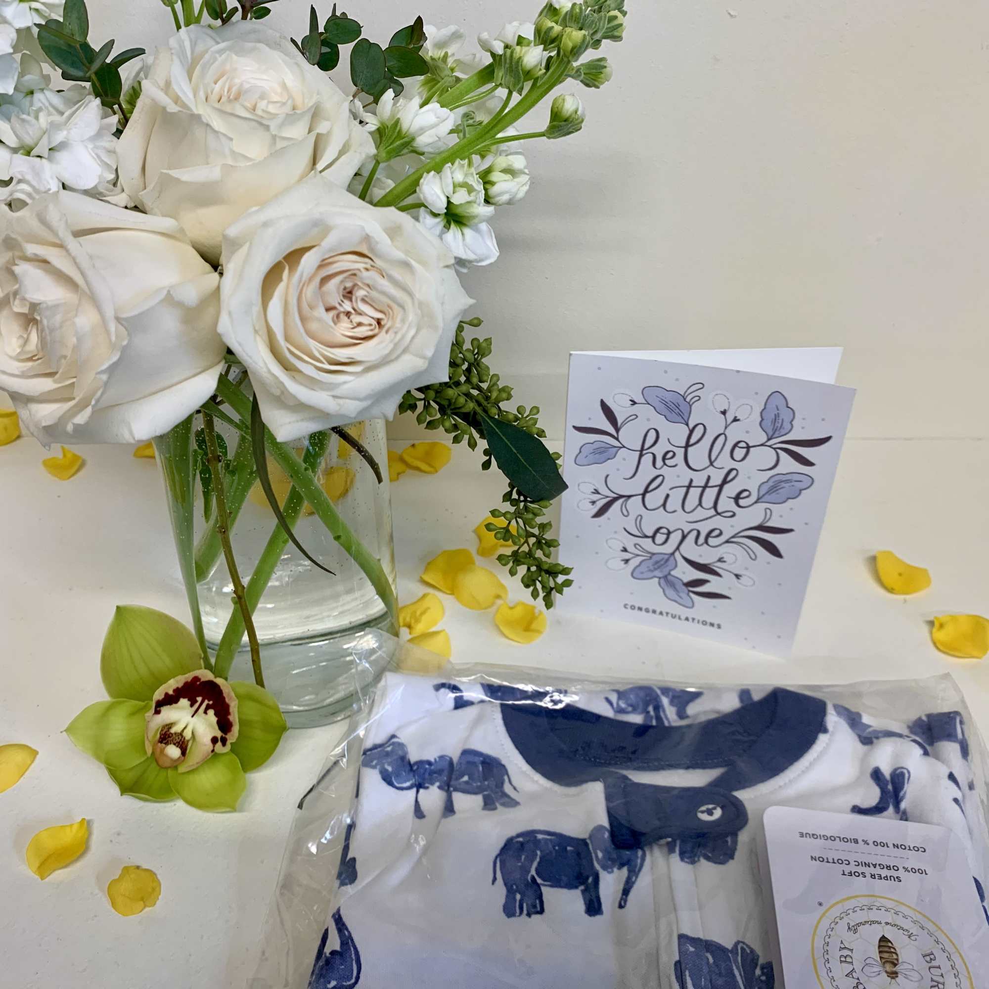 White roses and white stock in a clear glass vase accompanied with