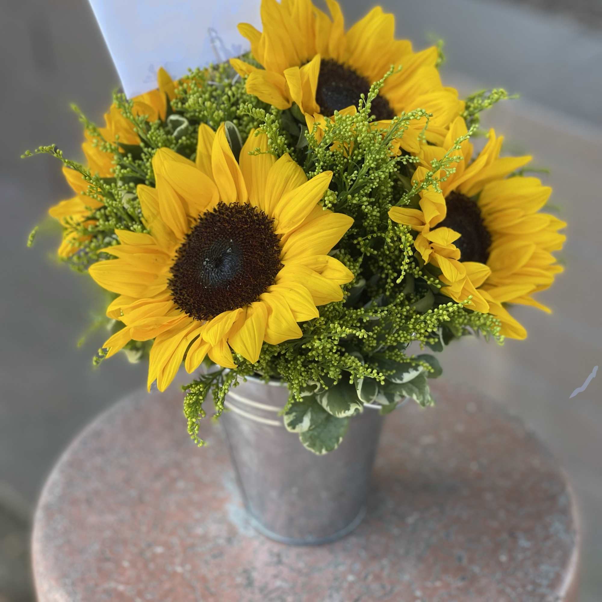 Blooming sunflowers and lemon tip nestled in a rustic tin can will