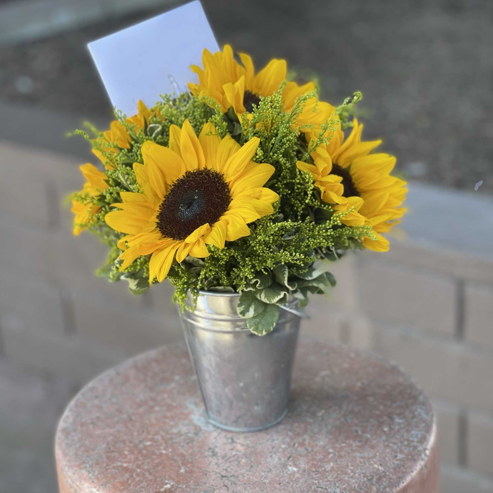 Blooming sunflowers and lemon tip nestled in a rustic tin can will