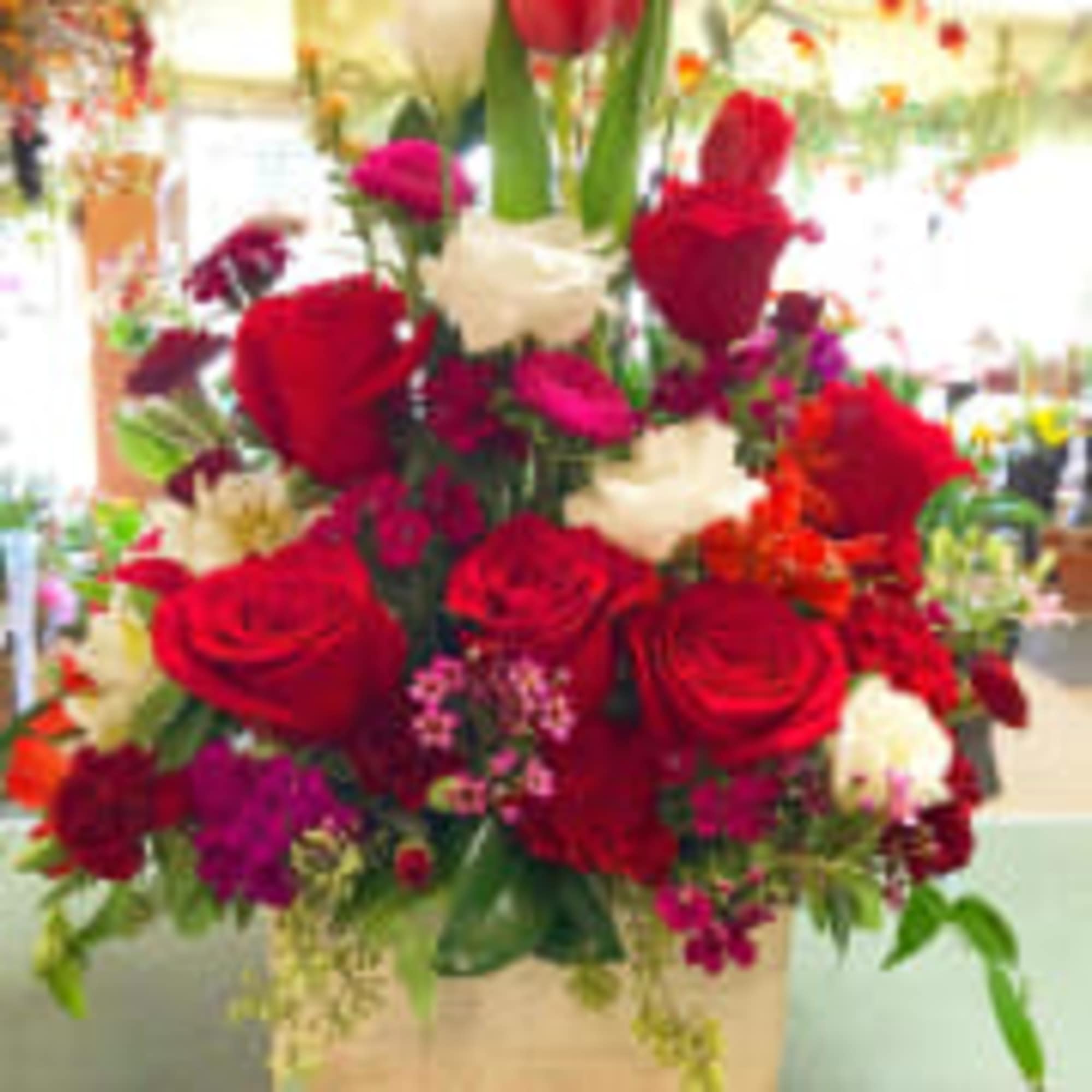 Wooden box filled with fresh cut roses, tulips , Lizzie, mini carnation