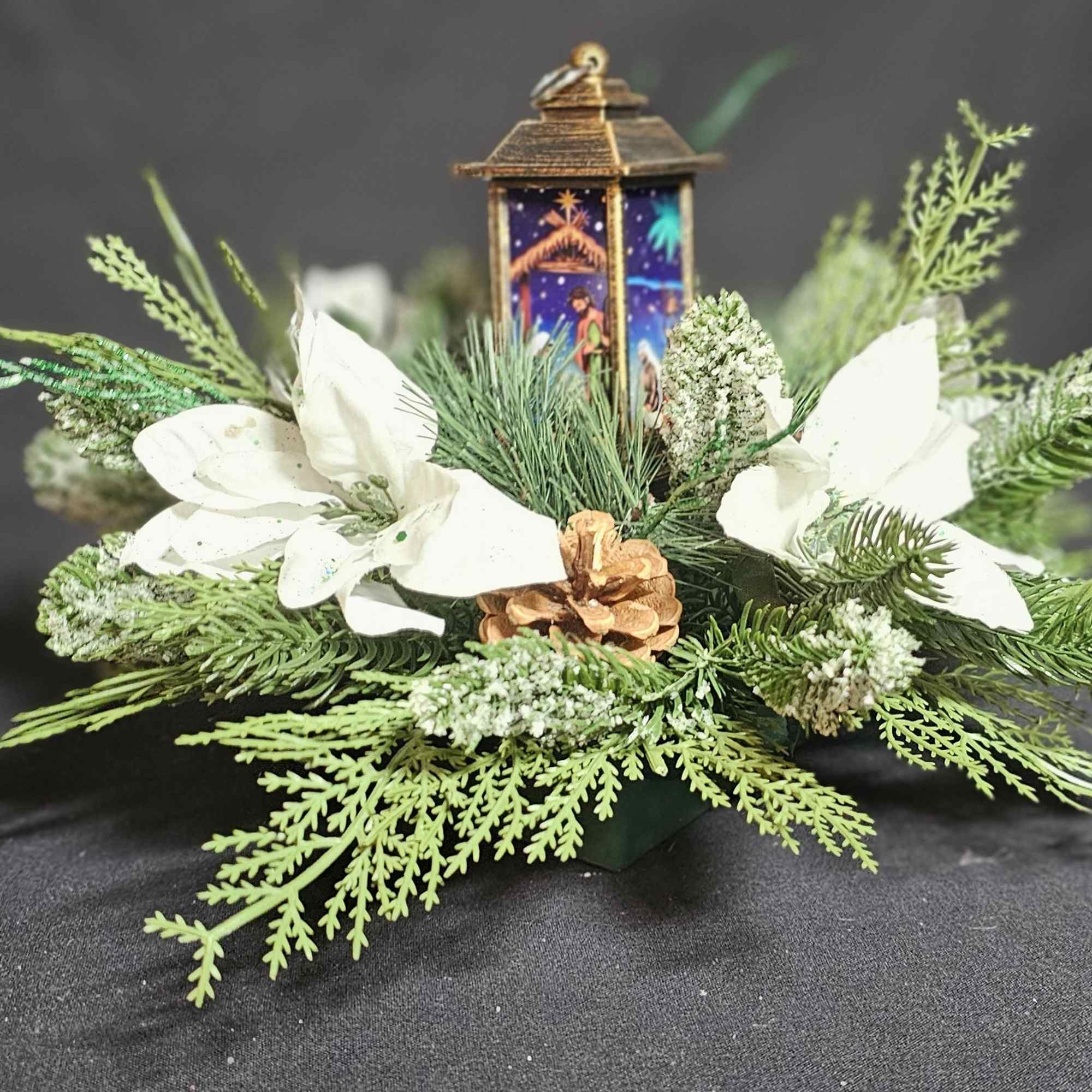 Classic center piece with white poinsettias around a nativity candle