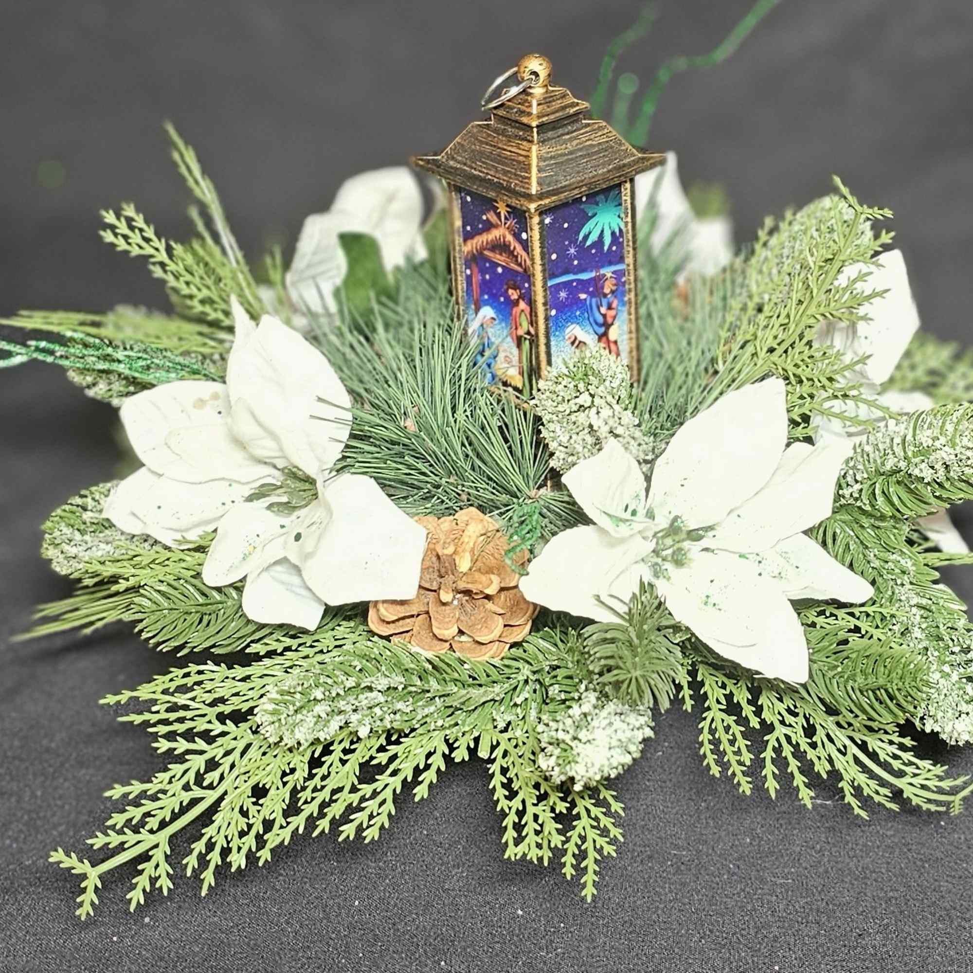 Classic center piece with white poinsettias around a nativity candle