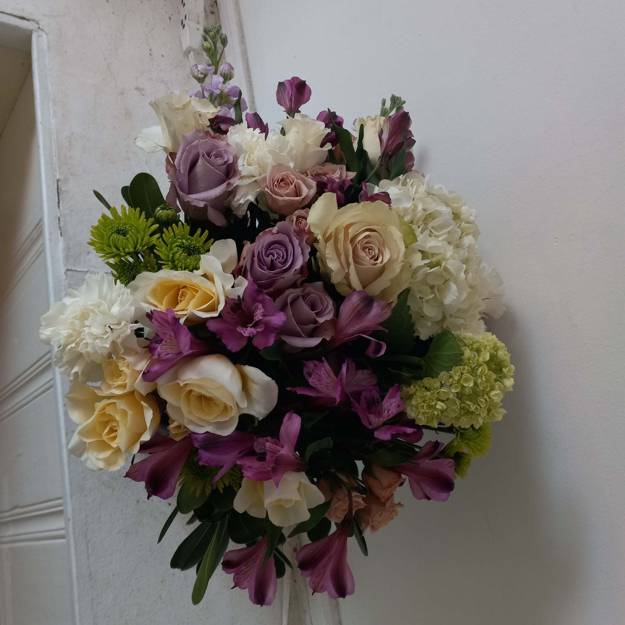 Light purple tone roses bland in with white and cream flowers