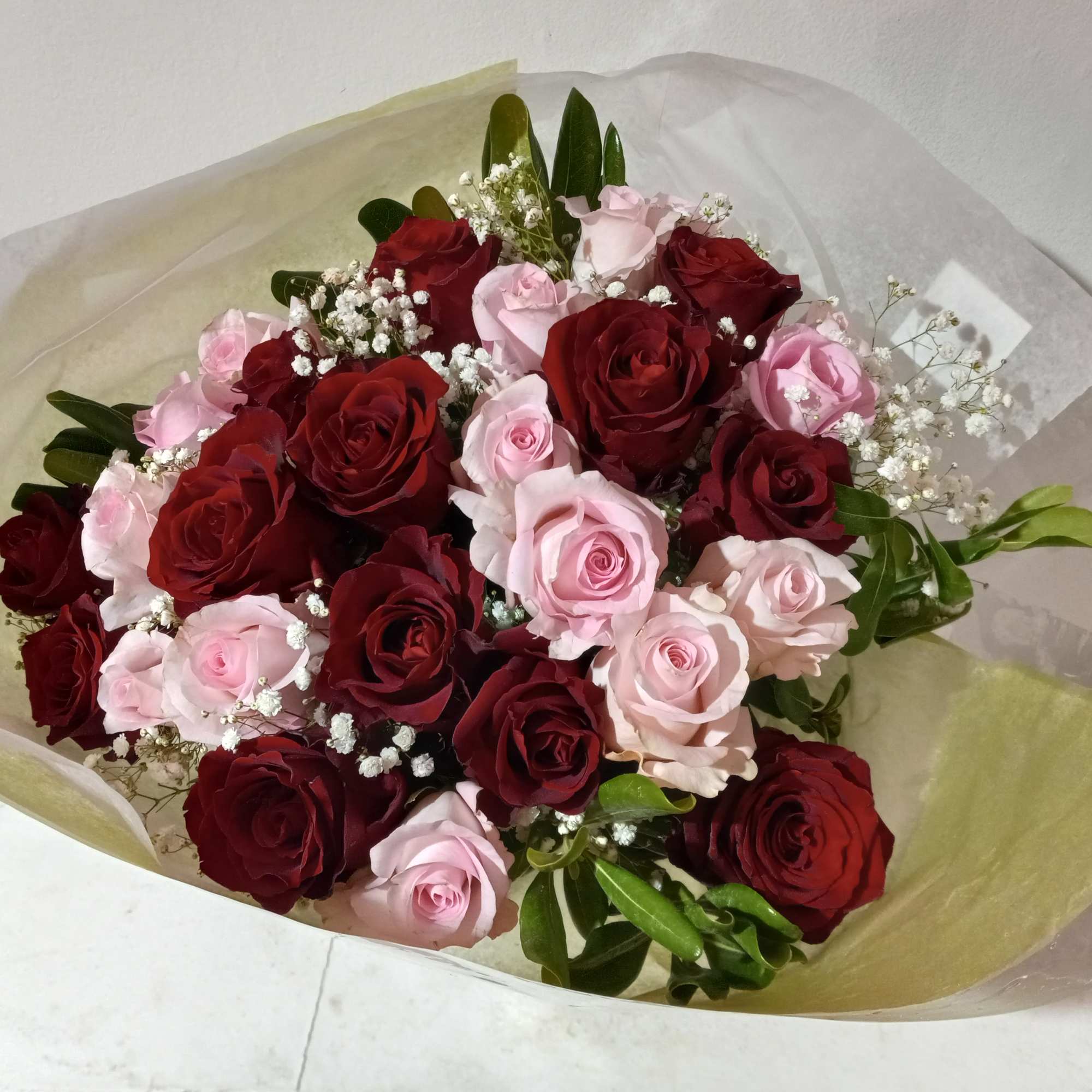 beautiful well rounded hand tied bouquet of red and pink roses with