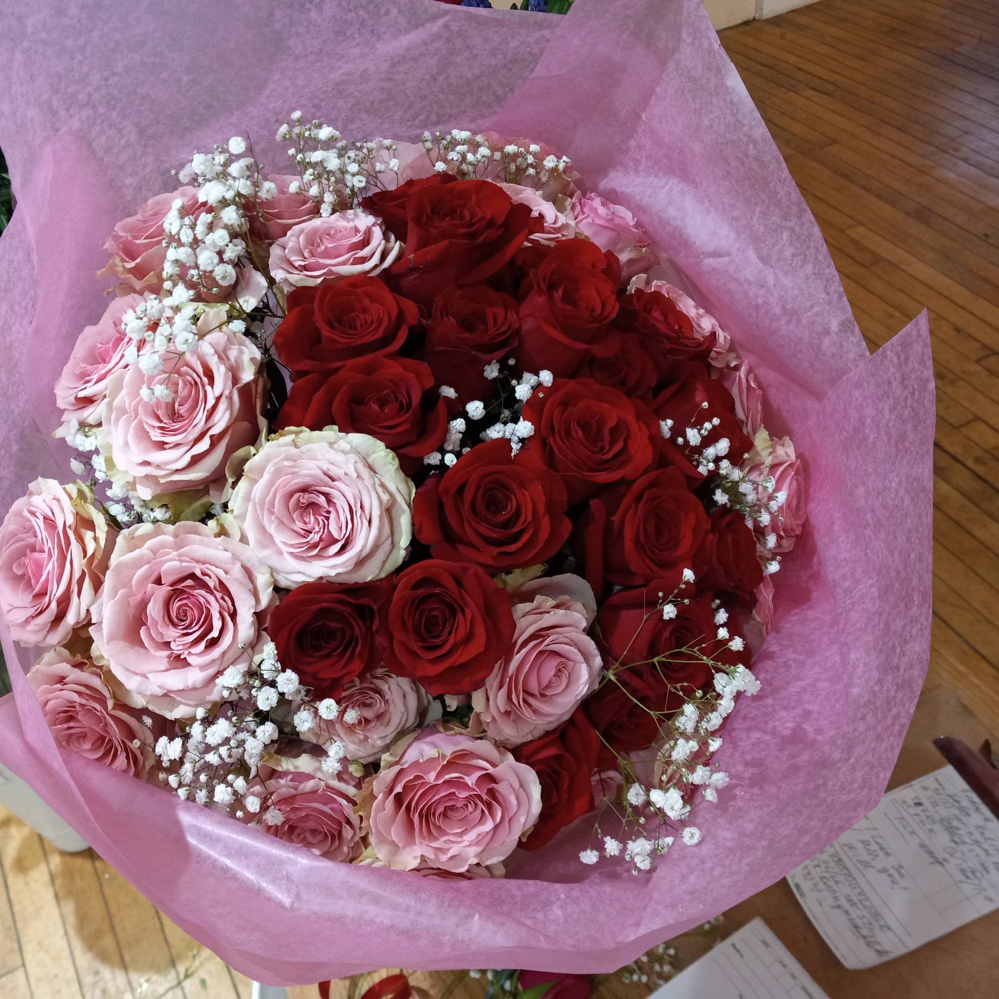 beautiful well rounded hand tied bouquet of red and pink roses with