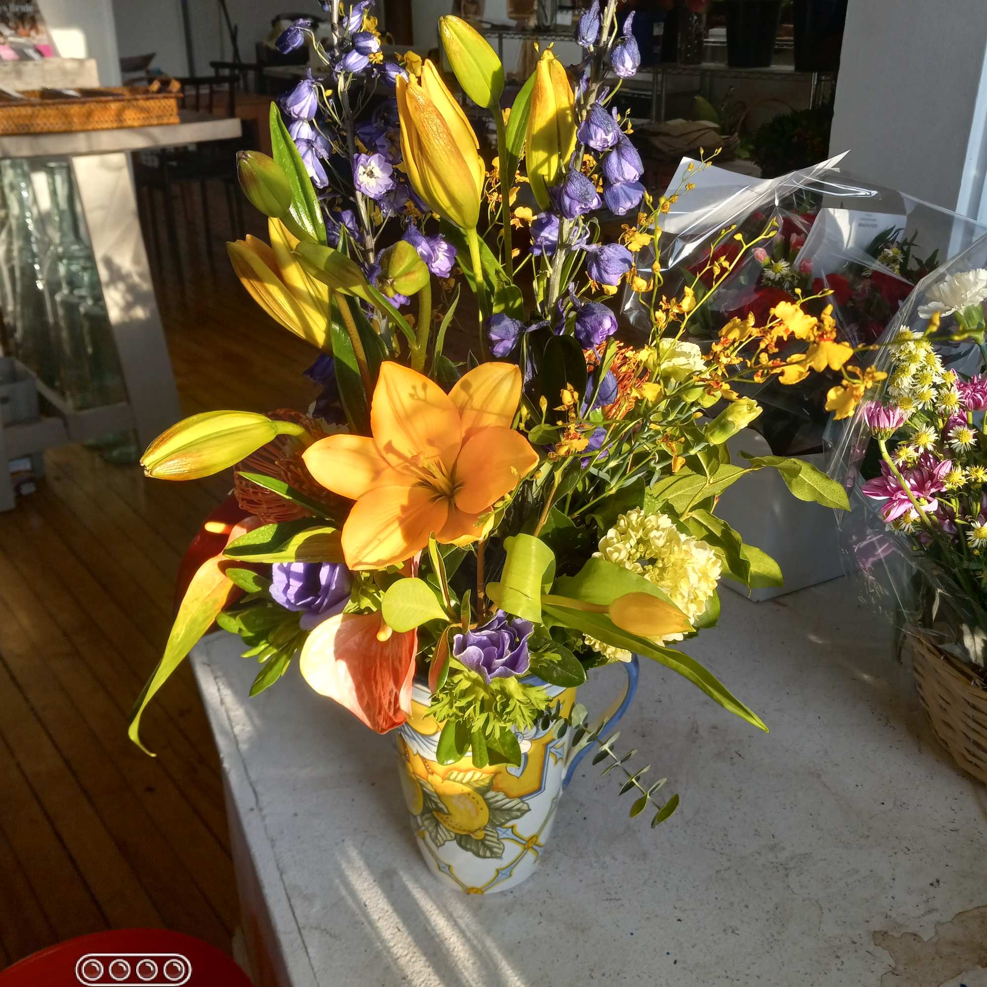 Exclusive Italian hand painted pitcher arranged with exotic tropical orchids, proteas, anturiums