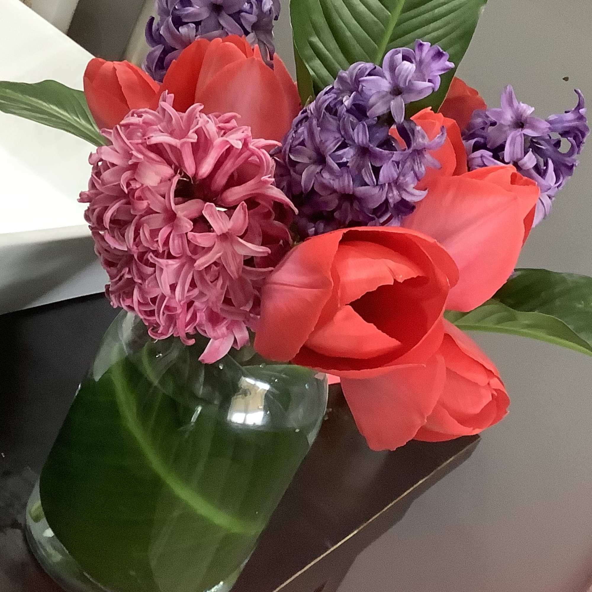 A vibrant spring arrangement of tulips hyacinths and daffodils.