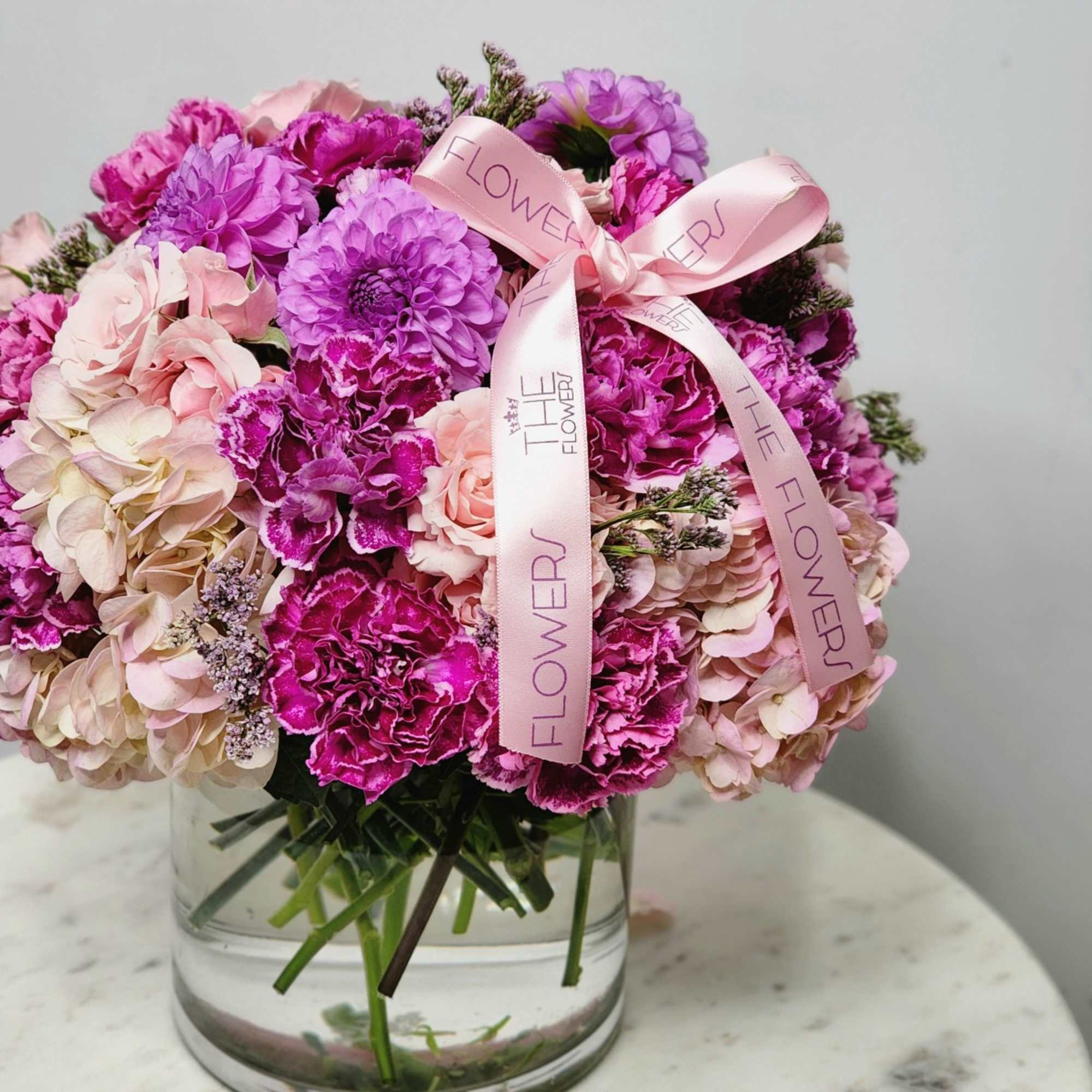 A vibrant bouquet blending the richness of purple dahlias with the delicate