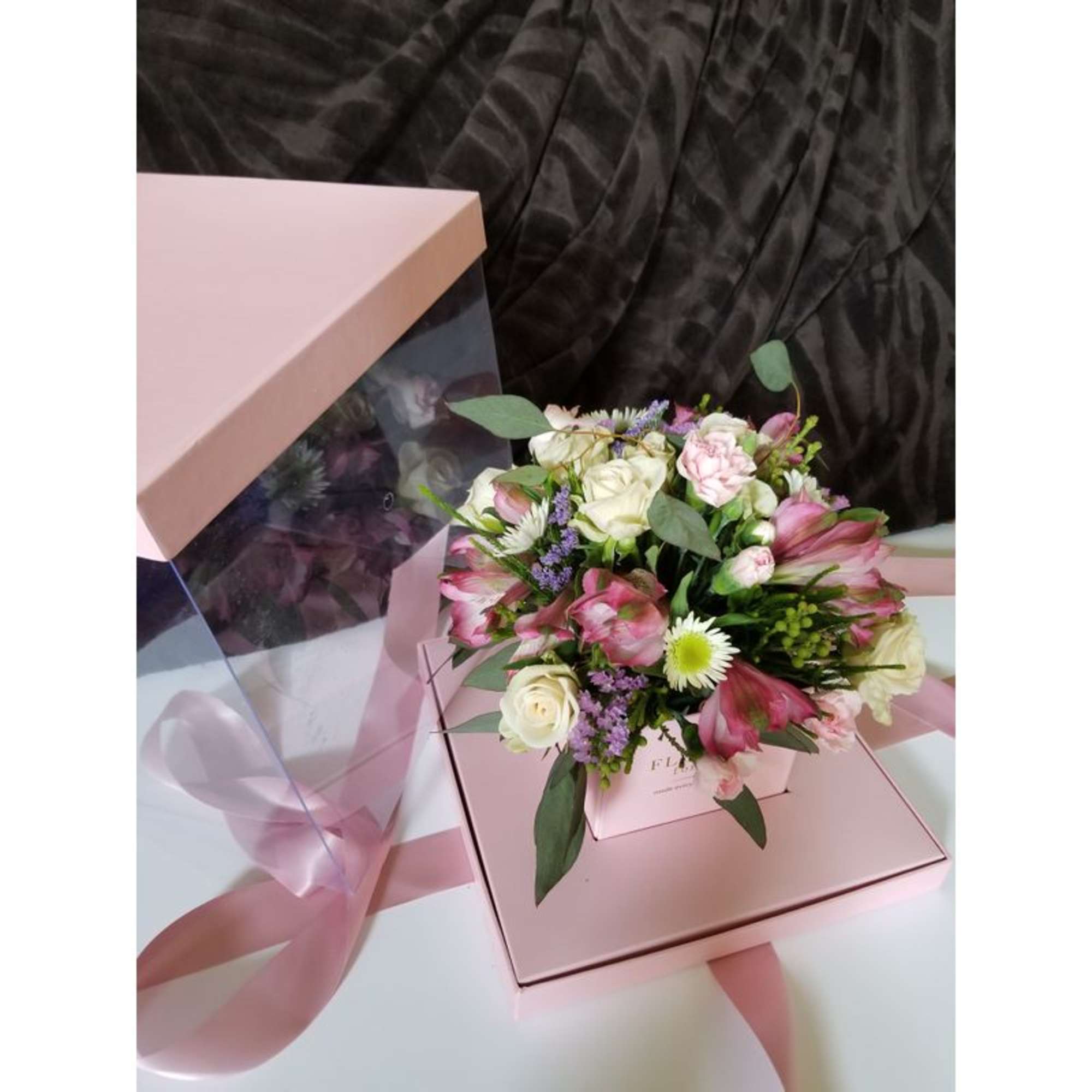 Box with clear sides. Arrangement includes spray roses, alstromeria, greenery and some Box with clear sides. Arrangement includes spray roses, alstromeria, greenery and some