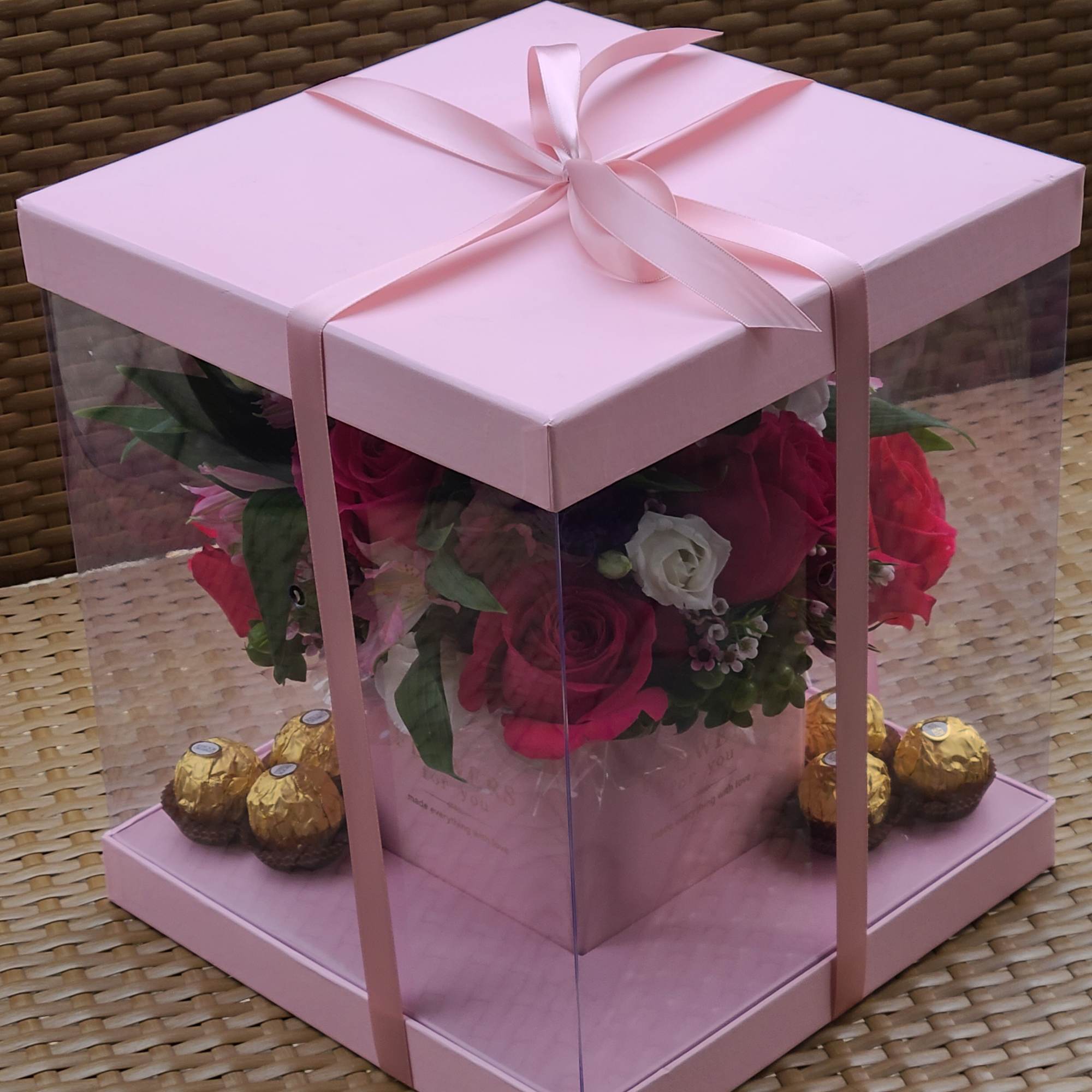 Box with clear sides. Arrangement includes spray roses, alstromeria, greenery and some Box with clear sides. Arrangement includes spray roses, alstromeria, greenery and some