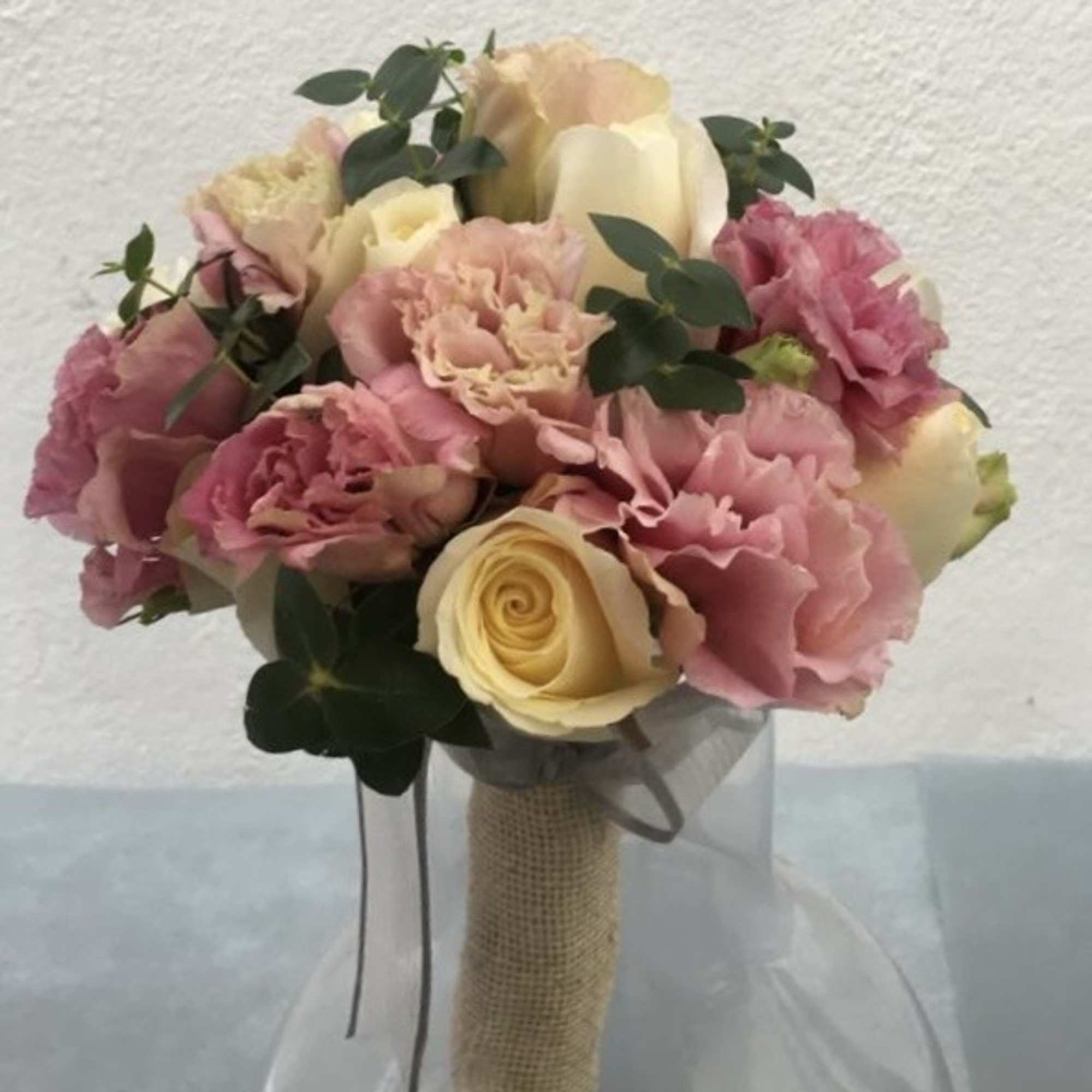 An original bridal bouquet of white roses and pink carnation hand tied