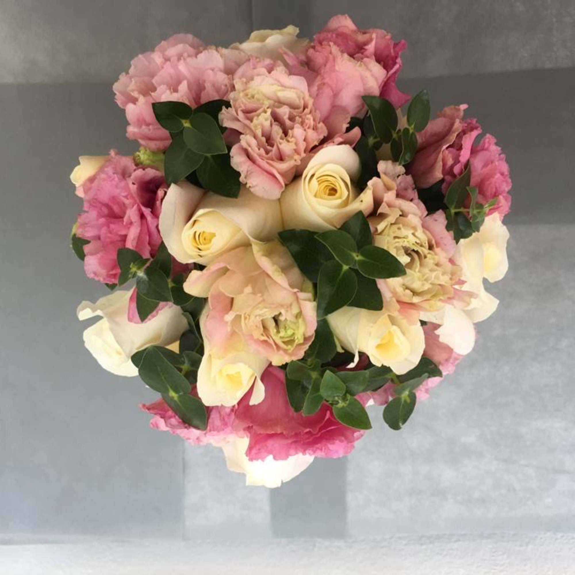 An original bridal bouquet of white roses and pink carnation hand tied