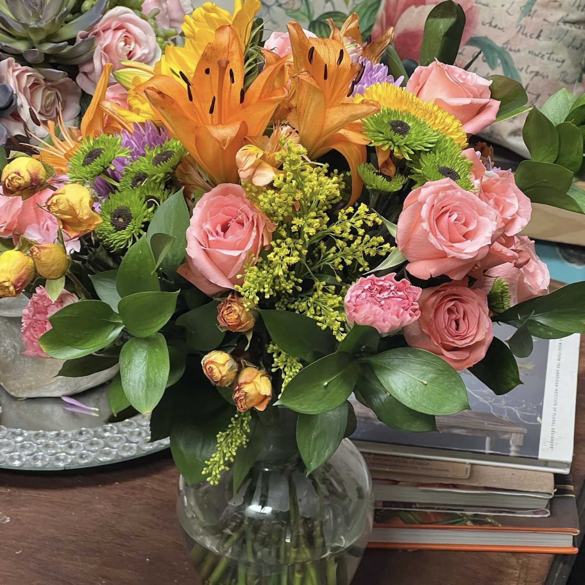 Designers Choice of Fall tones of fresh cut florals in Clear Vase