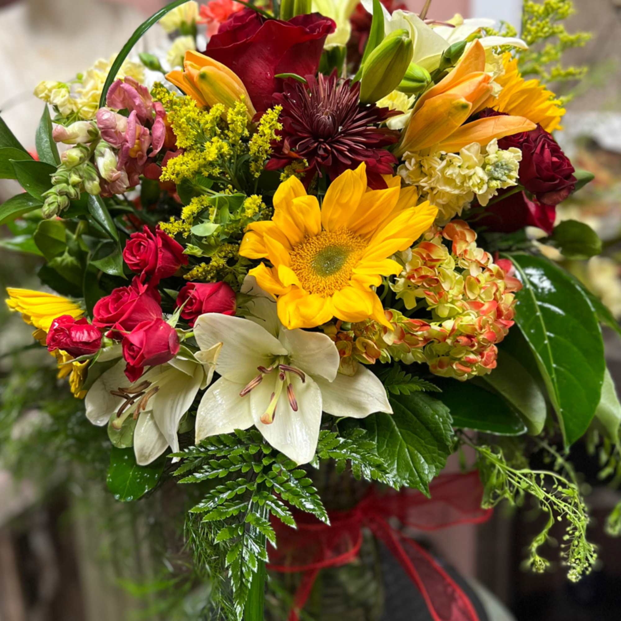 Designers Choice of Fall tones of fresh cut florals in Clear Vase