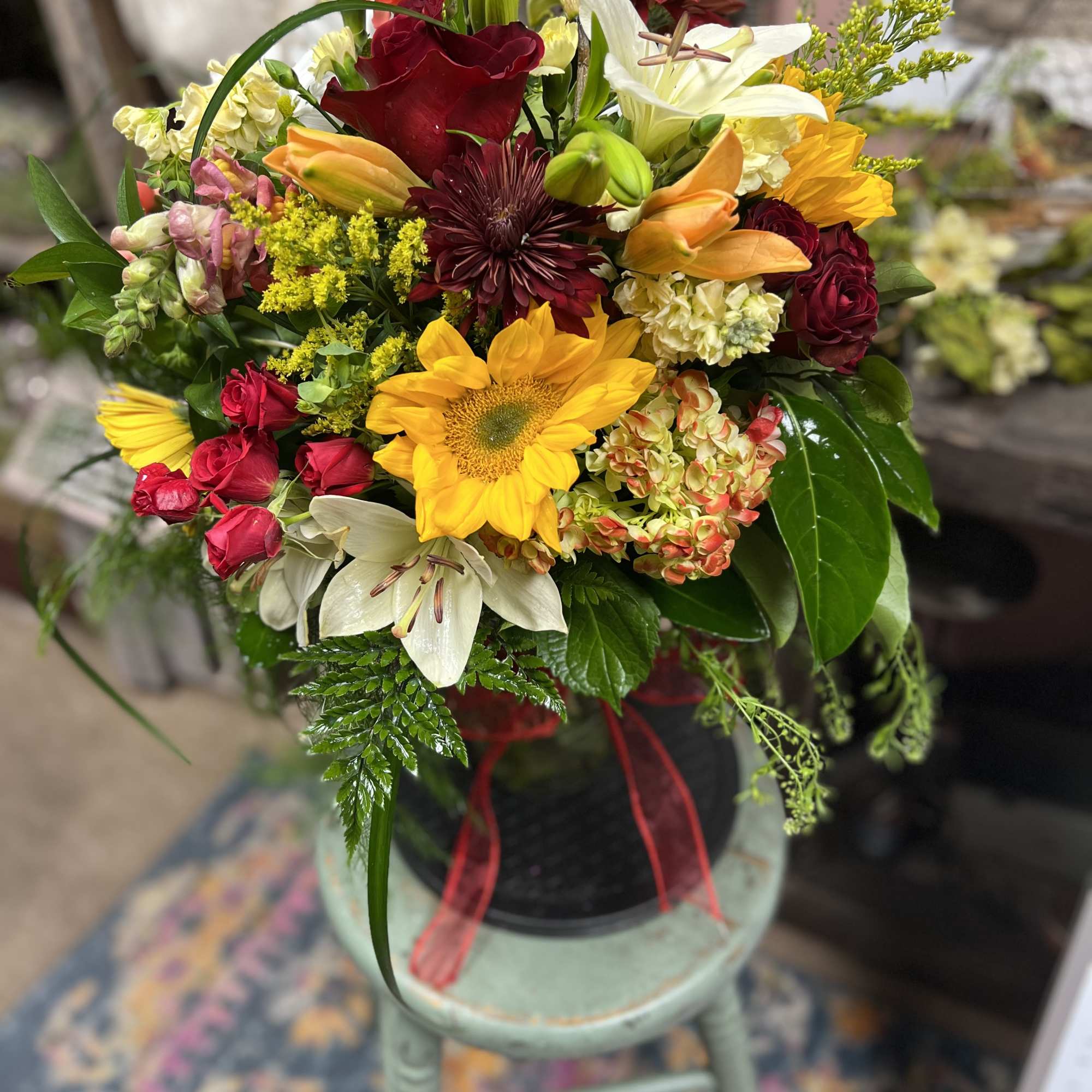 Designers Choice of Fall tones of fresh cut florals in Clear Vase