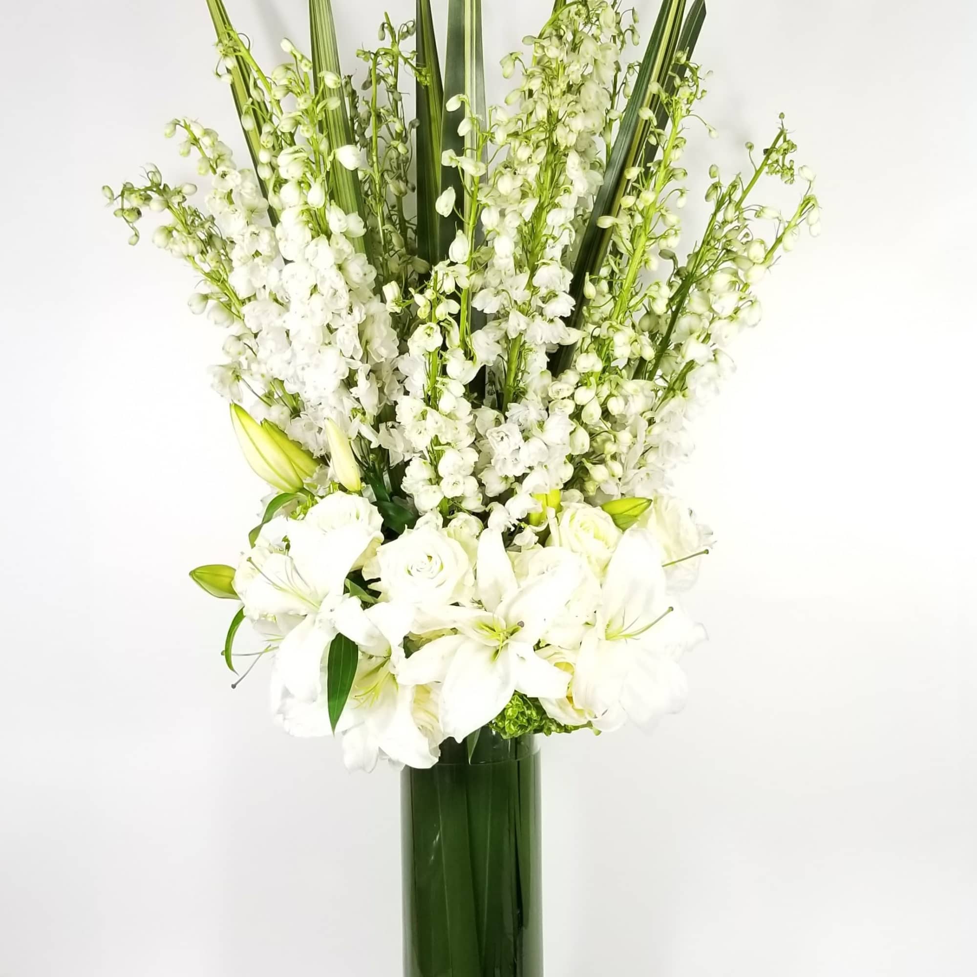 An arrangement made of roses, delphinium, hydrangeas, lilies and leaf An arrangement made of roses, delphinium, hydrangeas, lilies and leaf