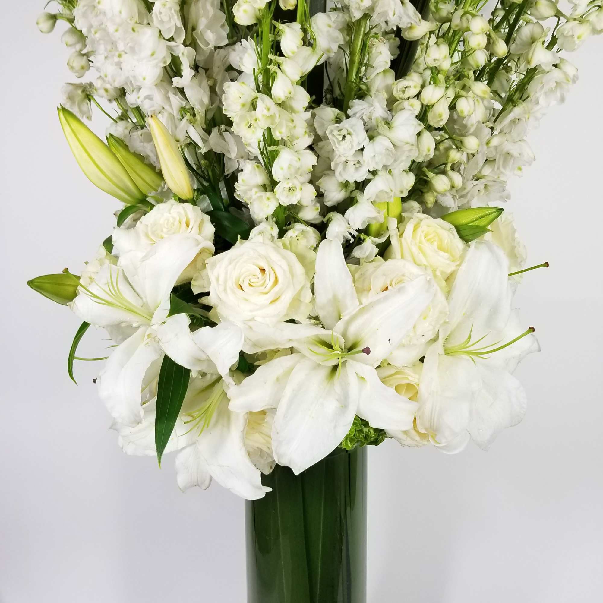 An arrangement made of roses, delphinium, hydrangeas, lilies and leaf An arrangement made of roses, delphinium, hydrangeas, lilies and leaf