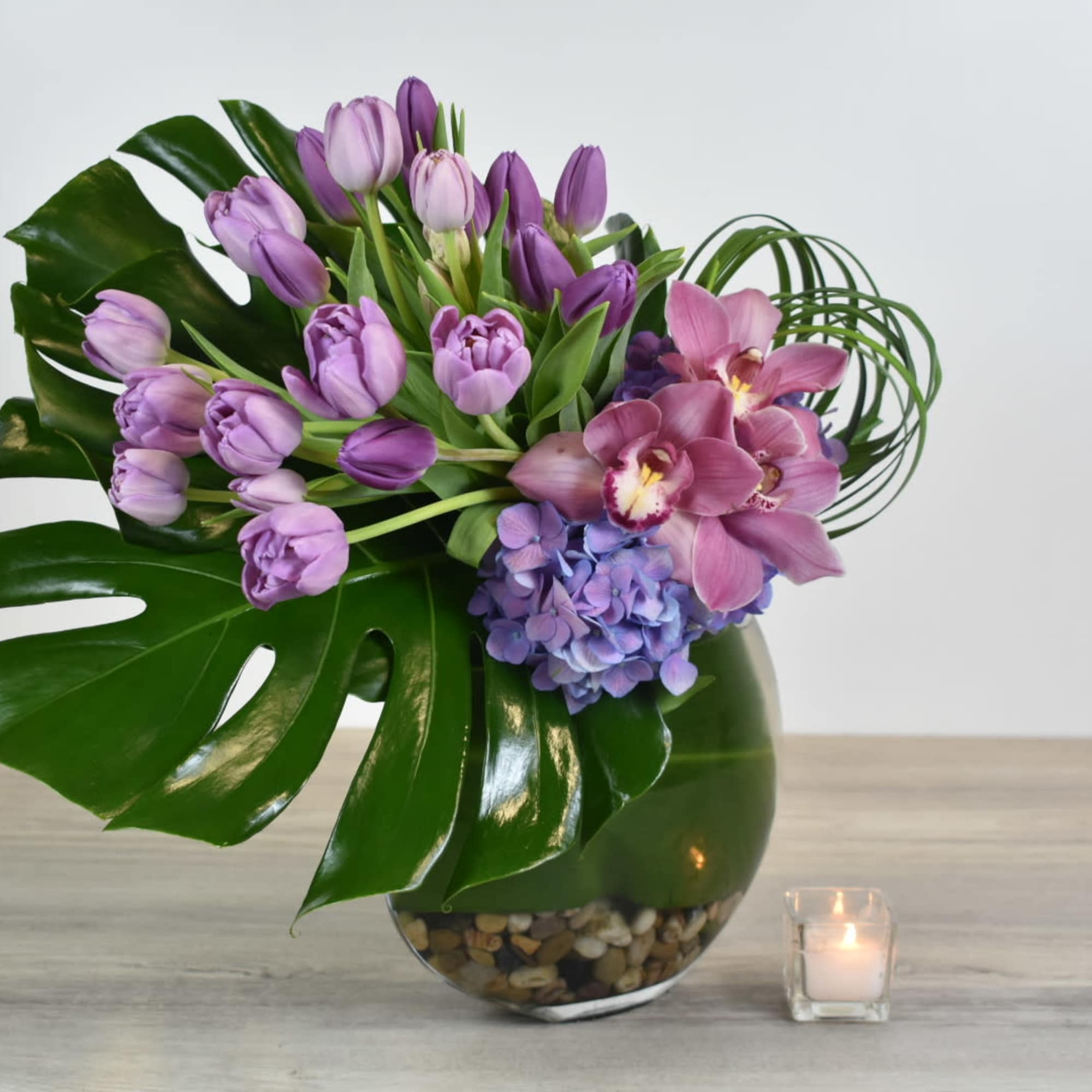 This Violet floral design comes in a glass vase, with purple tulips