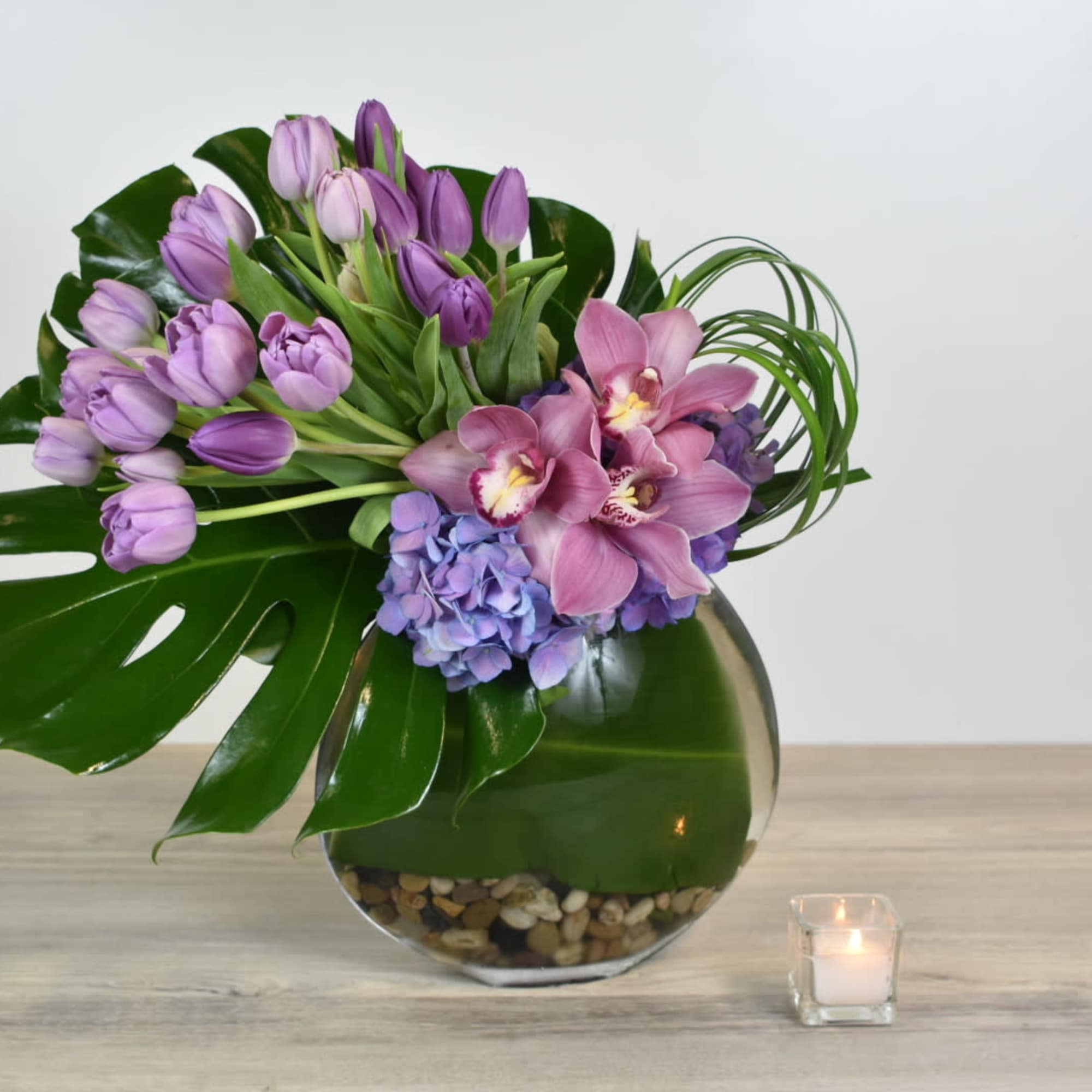 This Violet floral design comes in a glass vase, with purple tulips