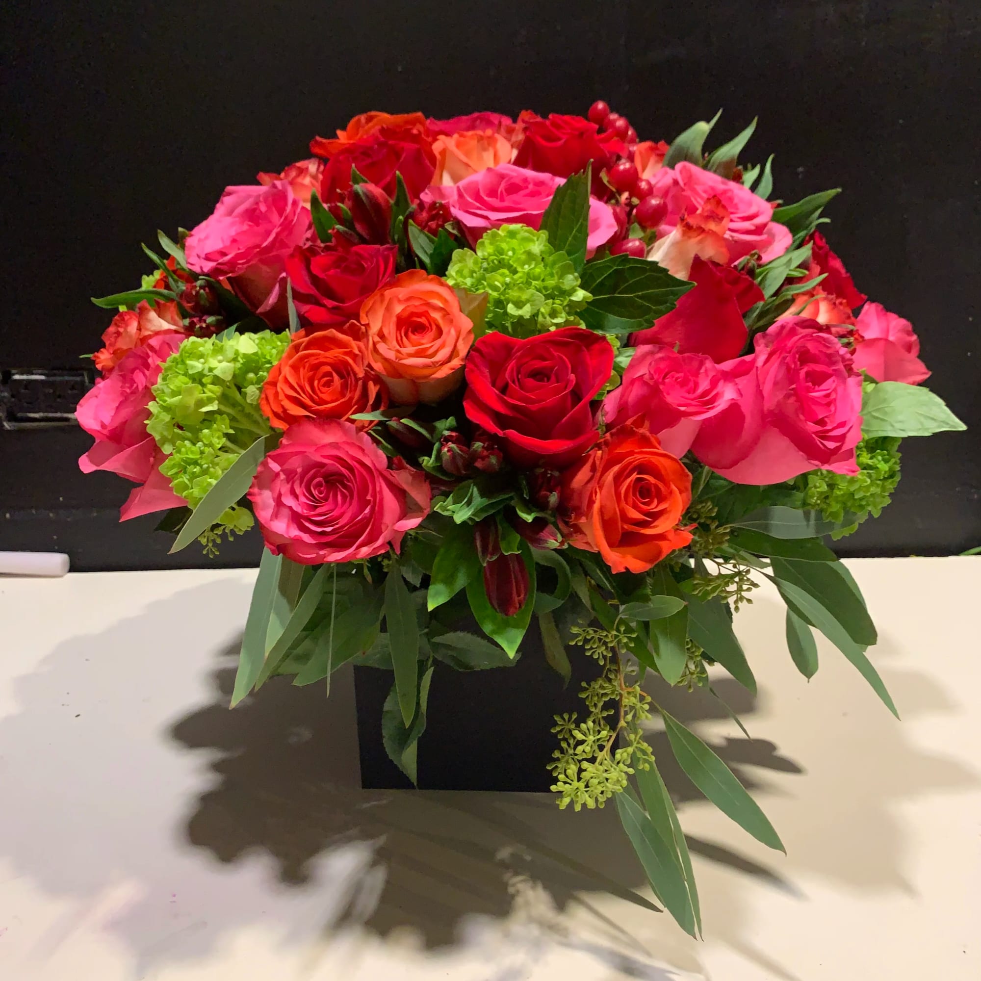 Red roses, orange roses, pink roses, dark pink roses and hydrangeas.