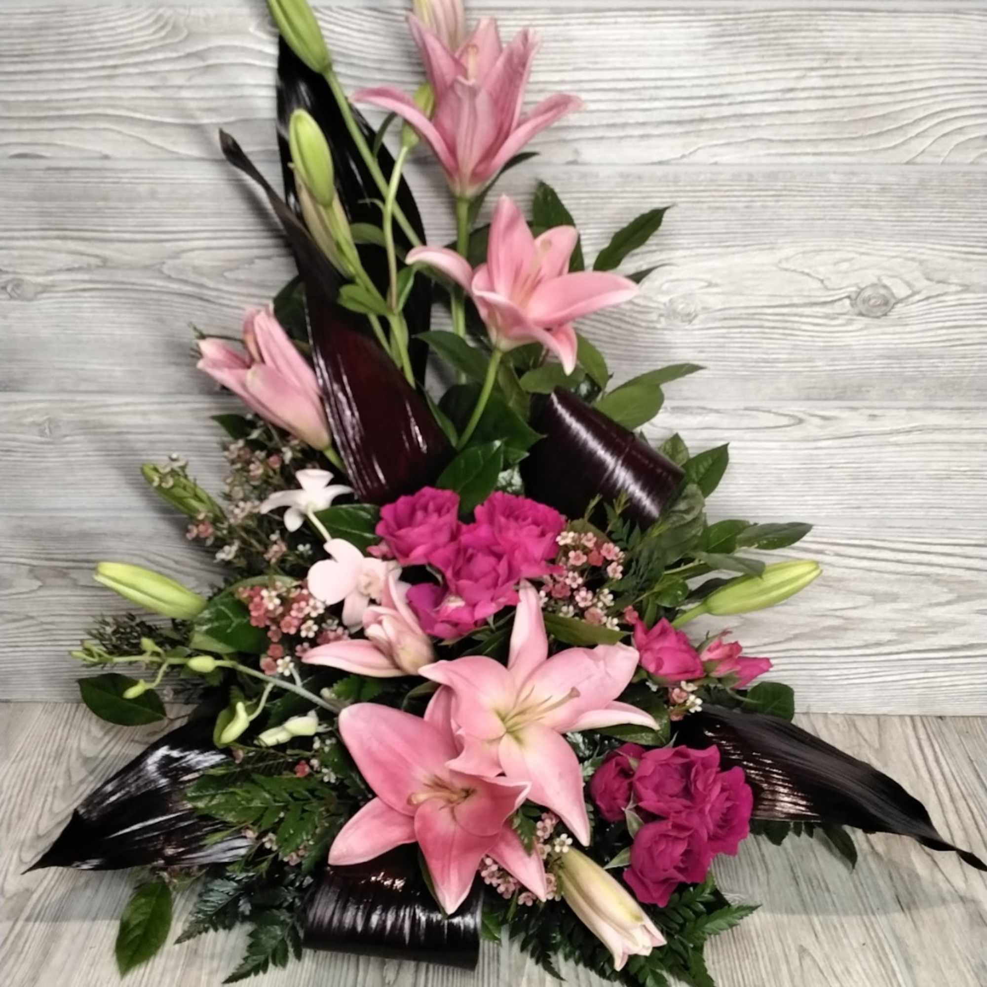 Lilies, Spray Roses, Orchids, Variety of Greens, and Filler. Lilies, Spray Roses, Orchids, Variety of Greens, and Filler.