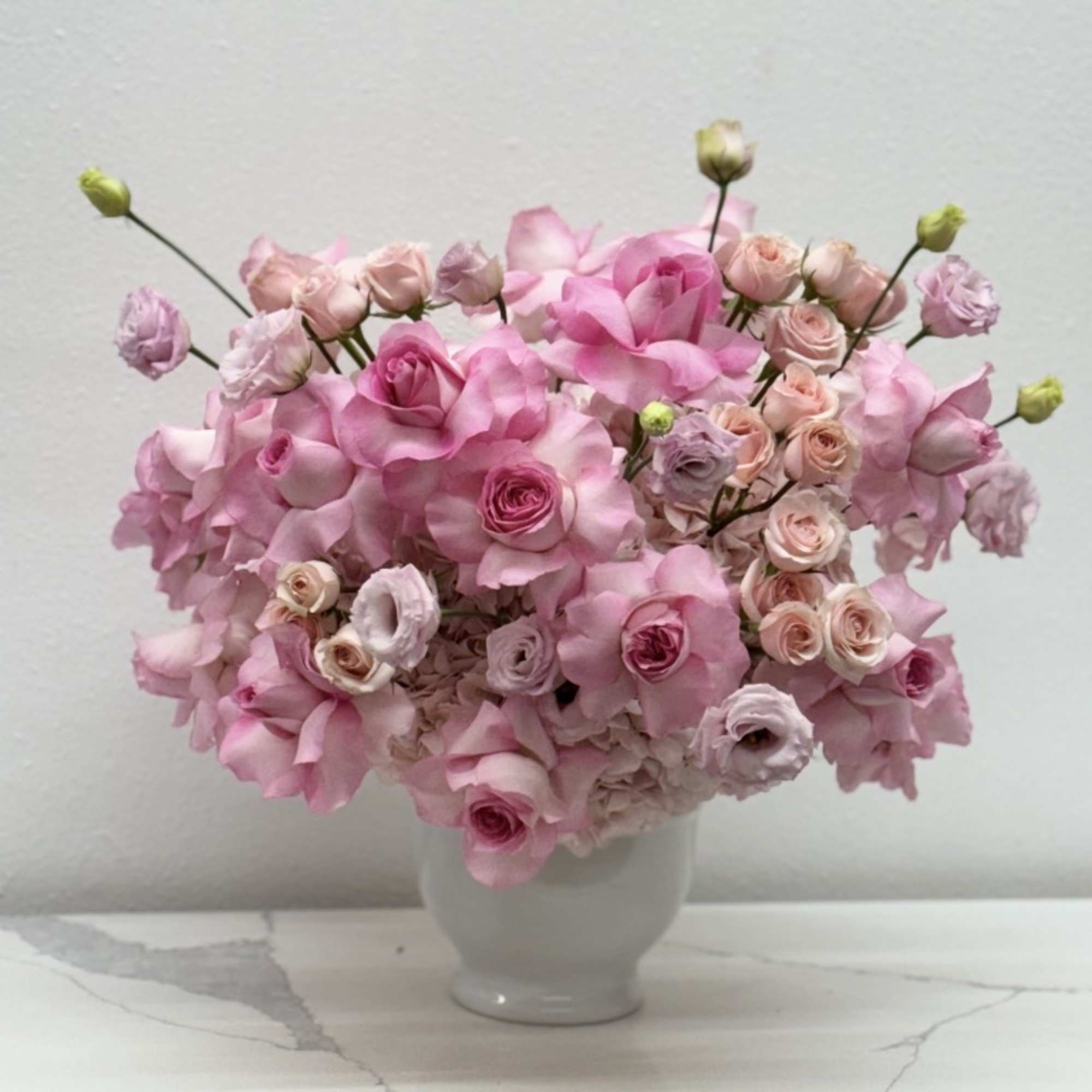 The modern style arrangement in the white vase is an exquisite display