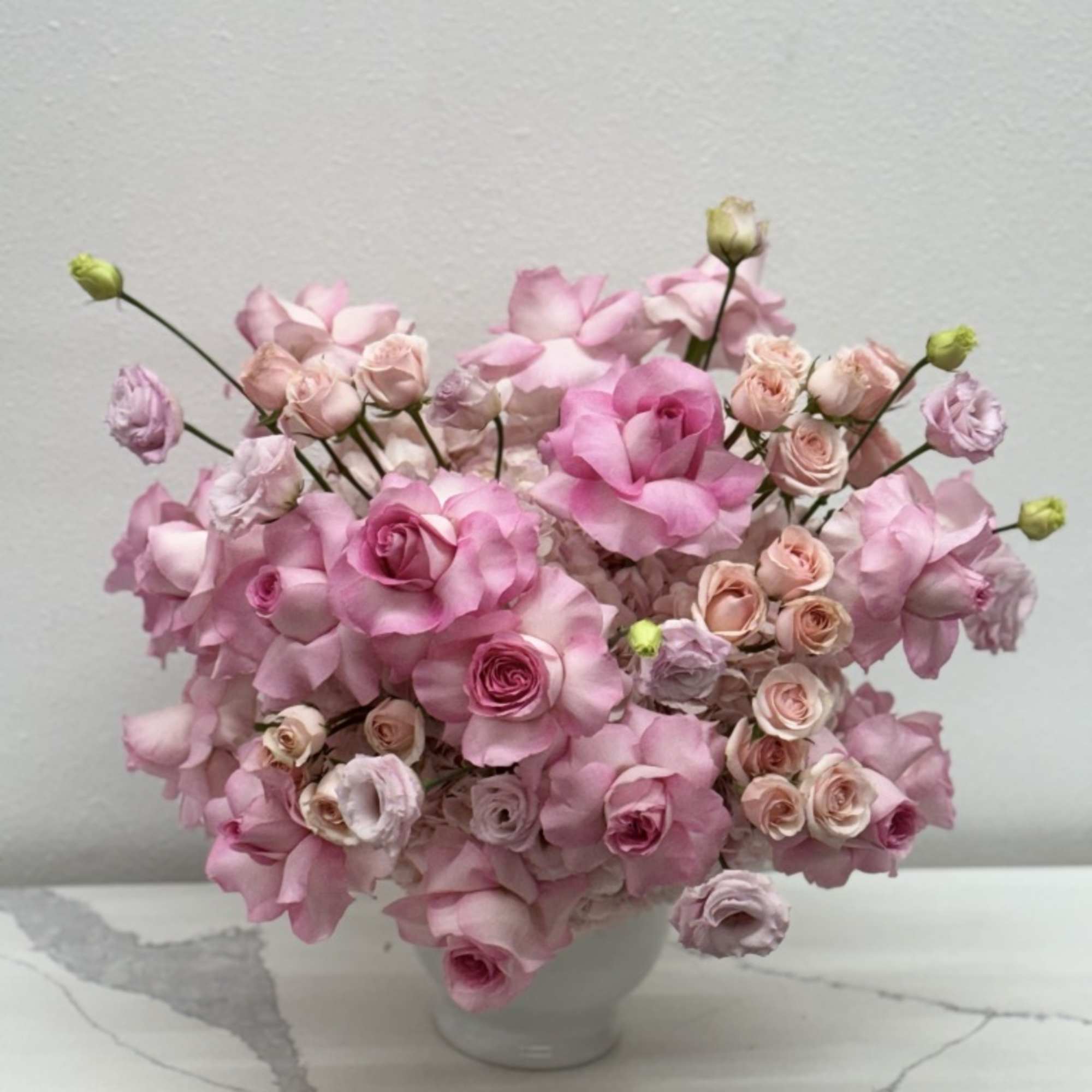 The modern style arrangement in the white vase is an exquisite display