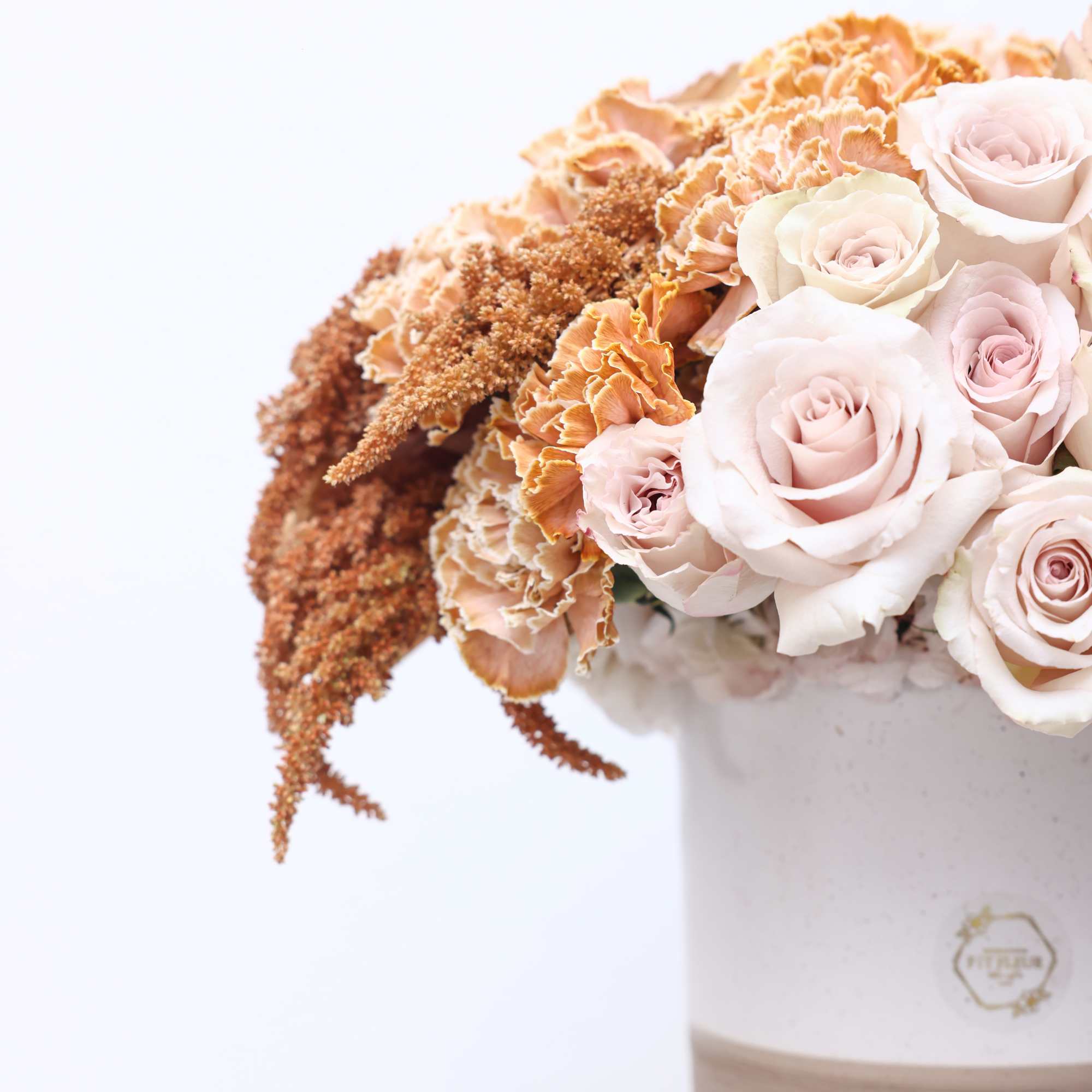 Billowy quicksand roses, carnations and radiant toffee roses are the highlight of