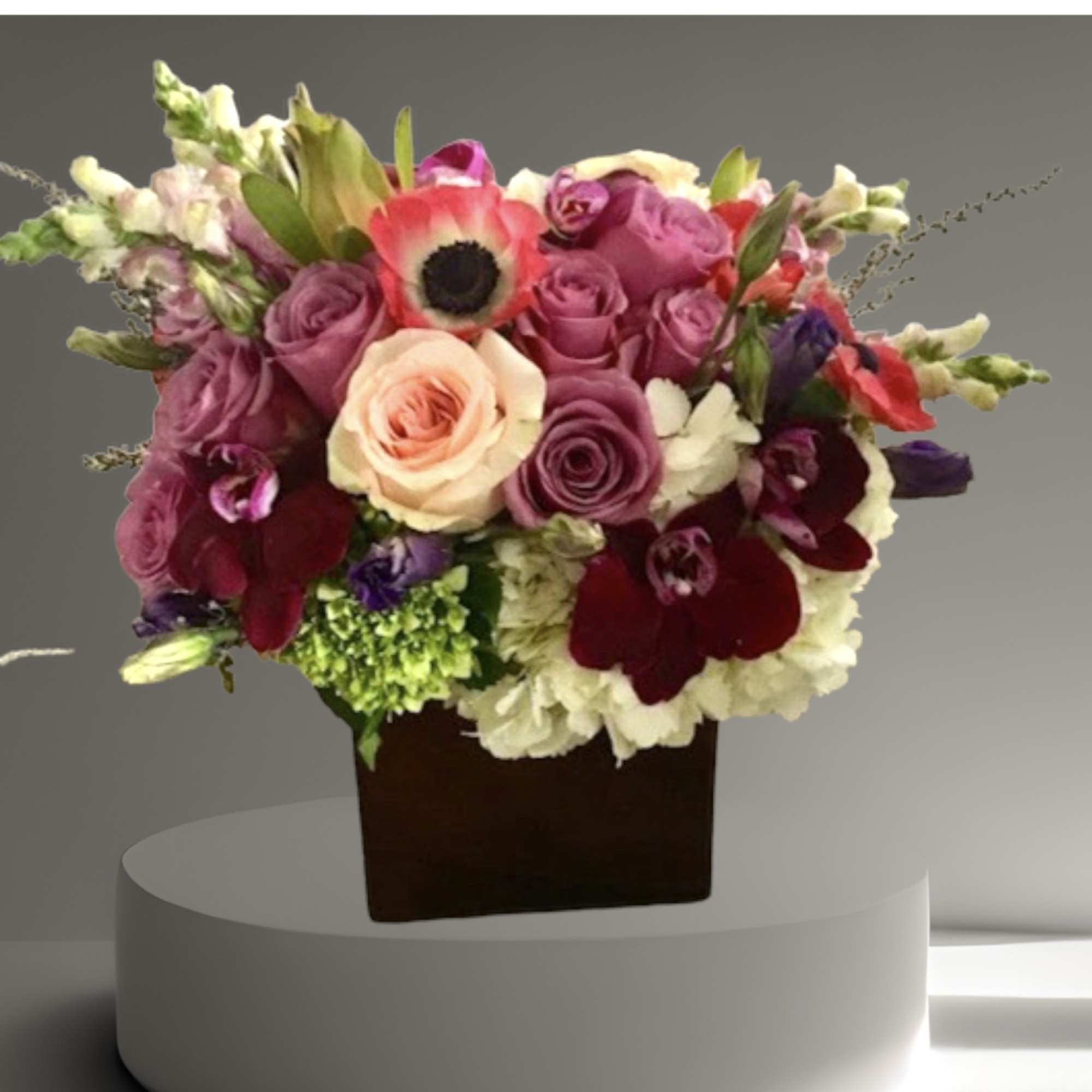 A beautiful arrangement in shades of purple and pink. Roses, hydrangea, orchids